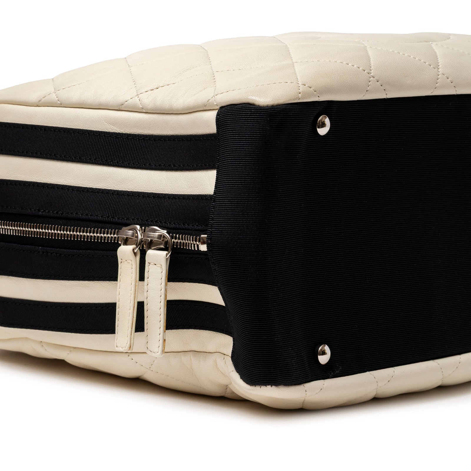 Close-up of Chanel CC Quilted Zip Shoulder Bag White & Black Lambskin Palladium Hardware showing bottom corner and dual zipper pulls