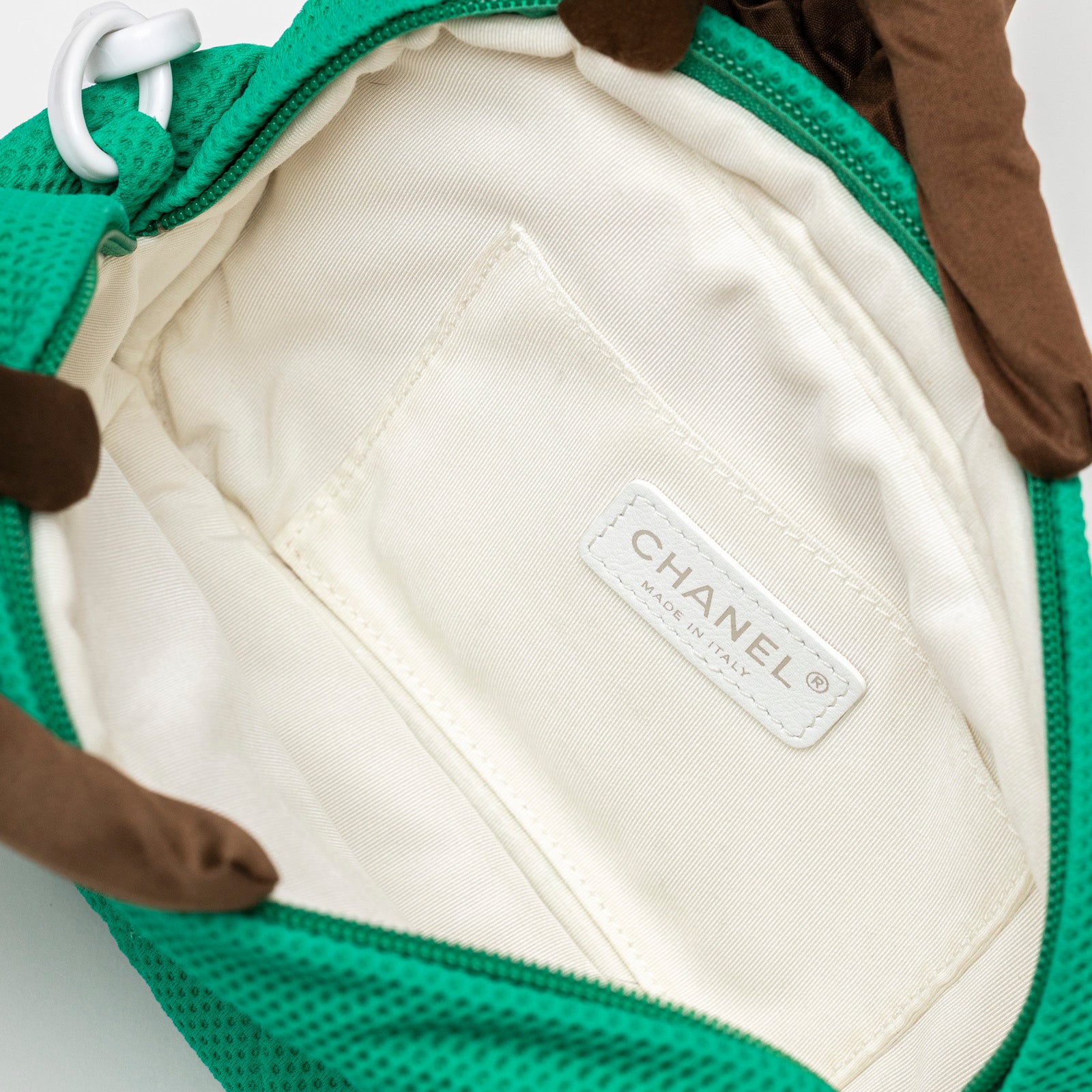 Interior close-up view of Chanel CC Sport Jersey Bag Green White Chain showing cream fabric lining and label detail
