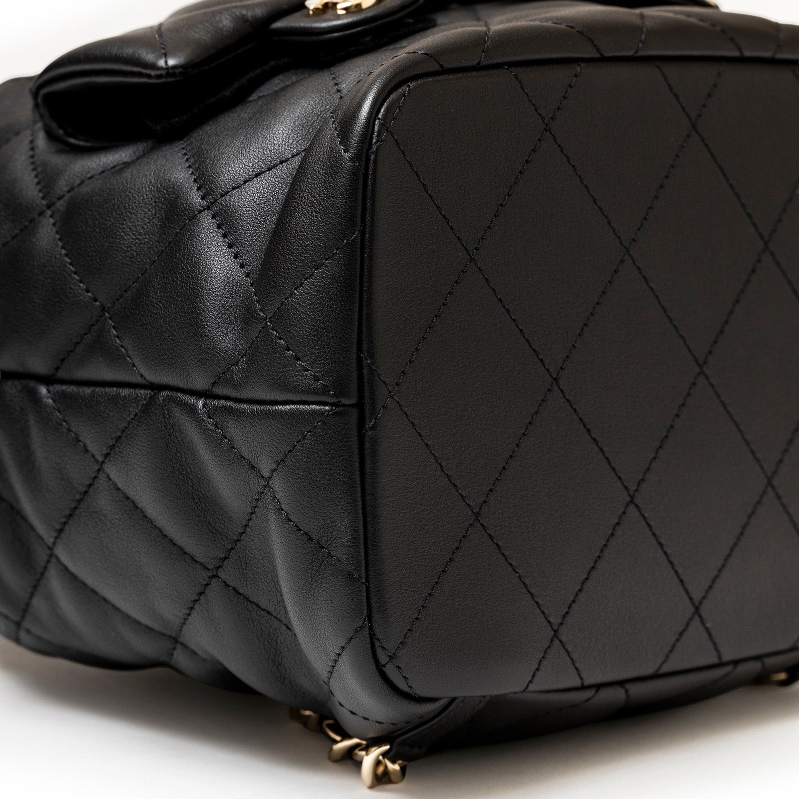 Close-up bottom view of Chanel Coco Mellow Backpack Calf Black Permabrass Hardware 23B showing quilted leather texture and stitching detail