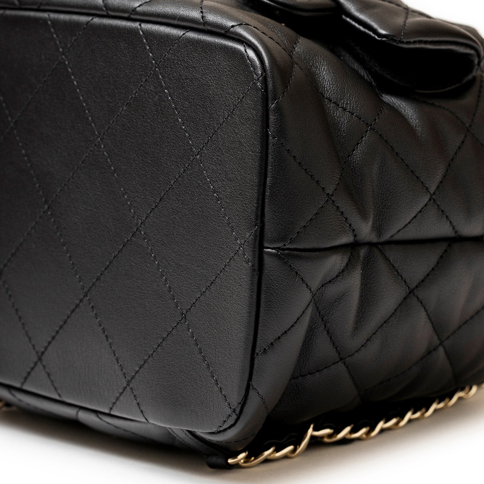 Close-up bottom view of Chanel Coco Mellow Backpack Calf Black Permabrass Hardware 23B showing quilted leather and hardware