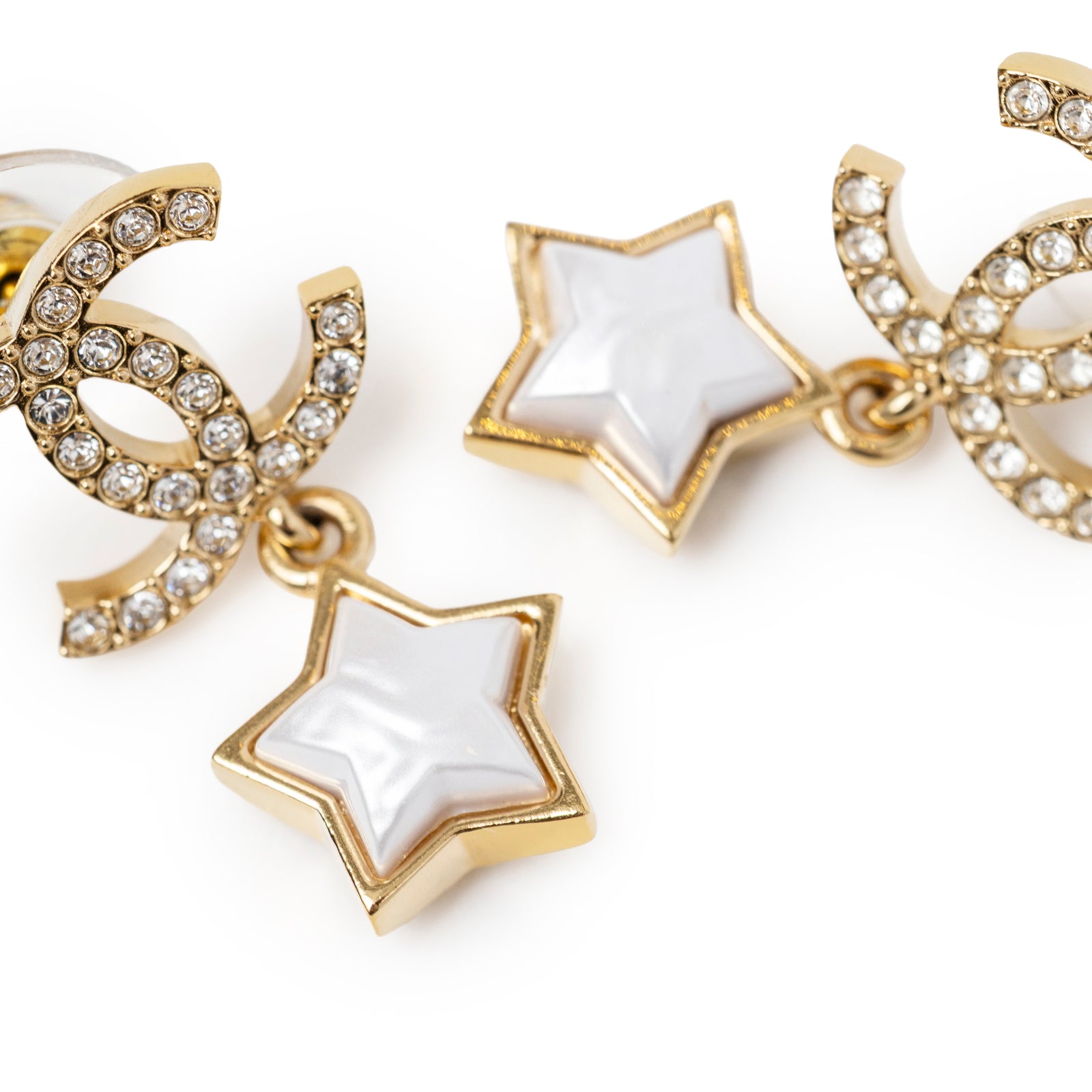 Close-up angled view of Chanel Crystal and Pearl CC Star Dangle Earrings Gold Hardware showing crystal-embellished logo and pearl star charm