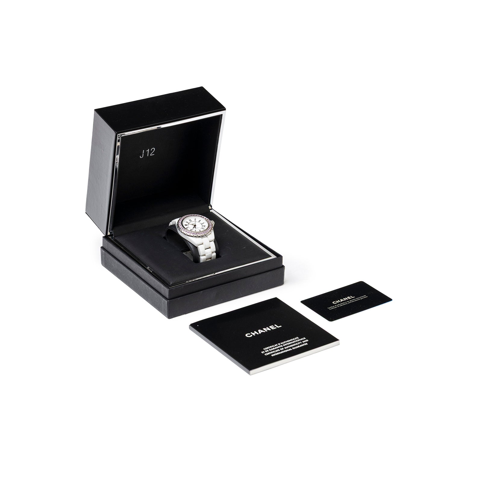 Angled view of Chanel J12 38mm Ceramic White Pink Sapphire Automatic Watch in black box with manuals and card