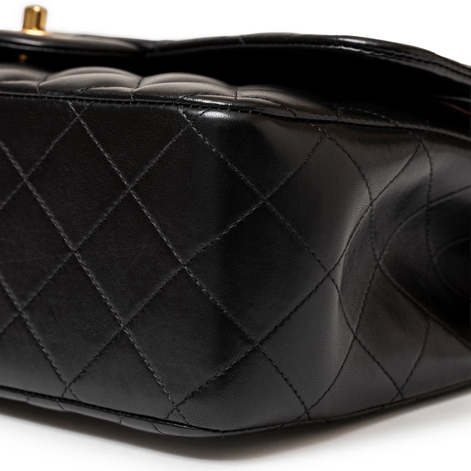 Close-up angled view of the black lambskin quilted leather corner on Chanel Jumbo Classic Double Flap Bag Black Lambskin Gold Hardware