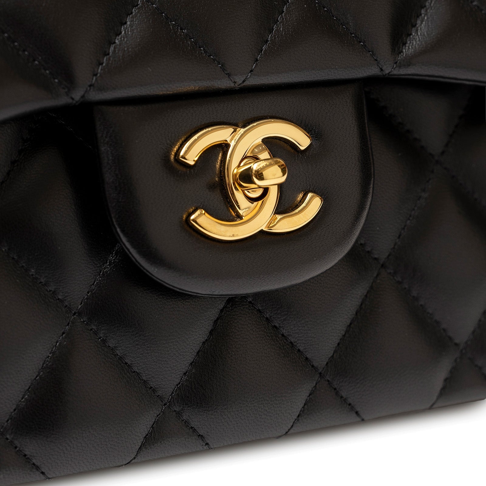 Close-up of gold hardware clasp on Chanel Jumbo Classic Double Flap Bag Black Lambskin Gold Hardware showing quilted leather detail