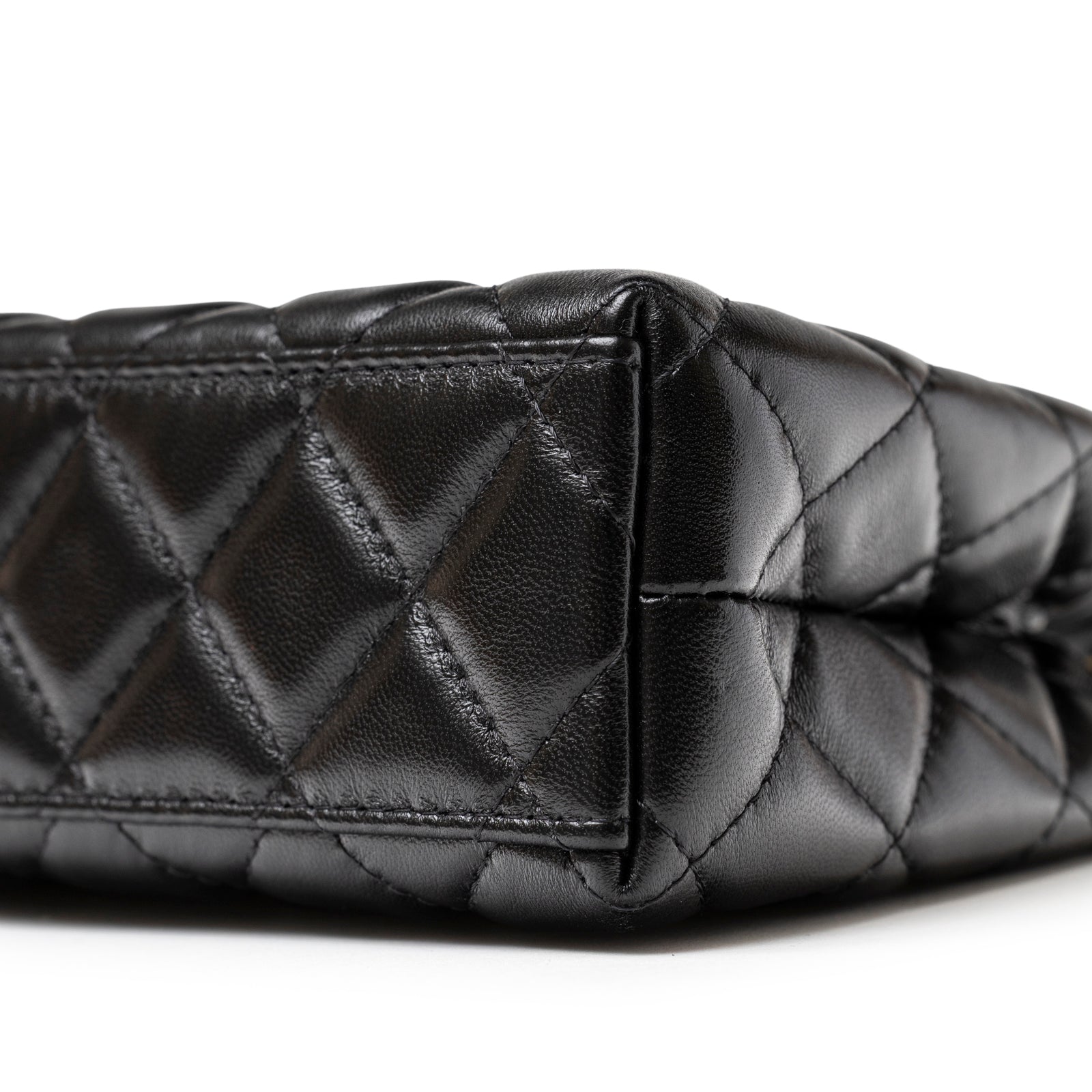 Close-up of Chanel Kelly Shopper Small Black Shiny Aged Calfskin Brushed Gold Hardware corner with quilted stitching detail