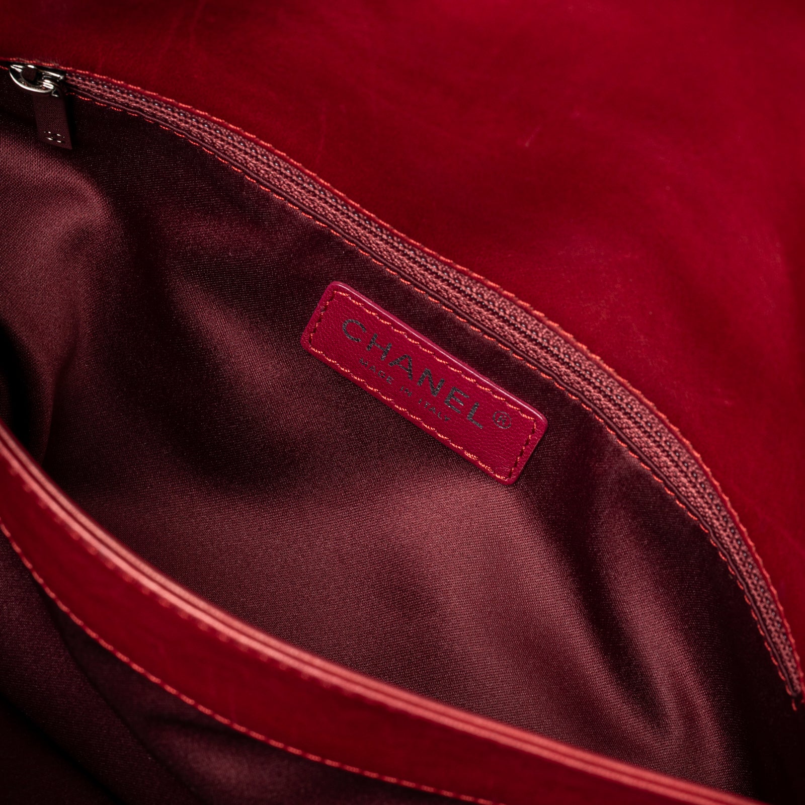 Inside view of Chanel Maxi 3 Accordion Flap Bag Lambskin Red Palladium Hardware showing interior zipper and logo patch detail