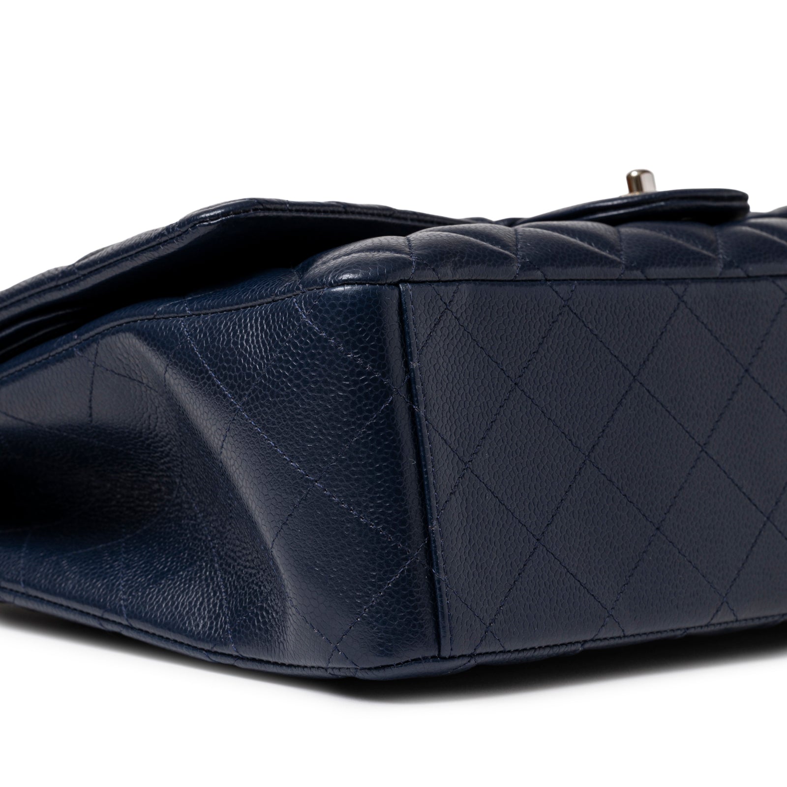 Bottom angled view of Chanel Maxi Classic Double Flap Caviar Navy Palladium Hardware showing quilted leather base detail