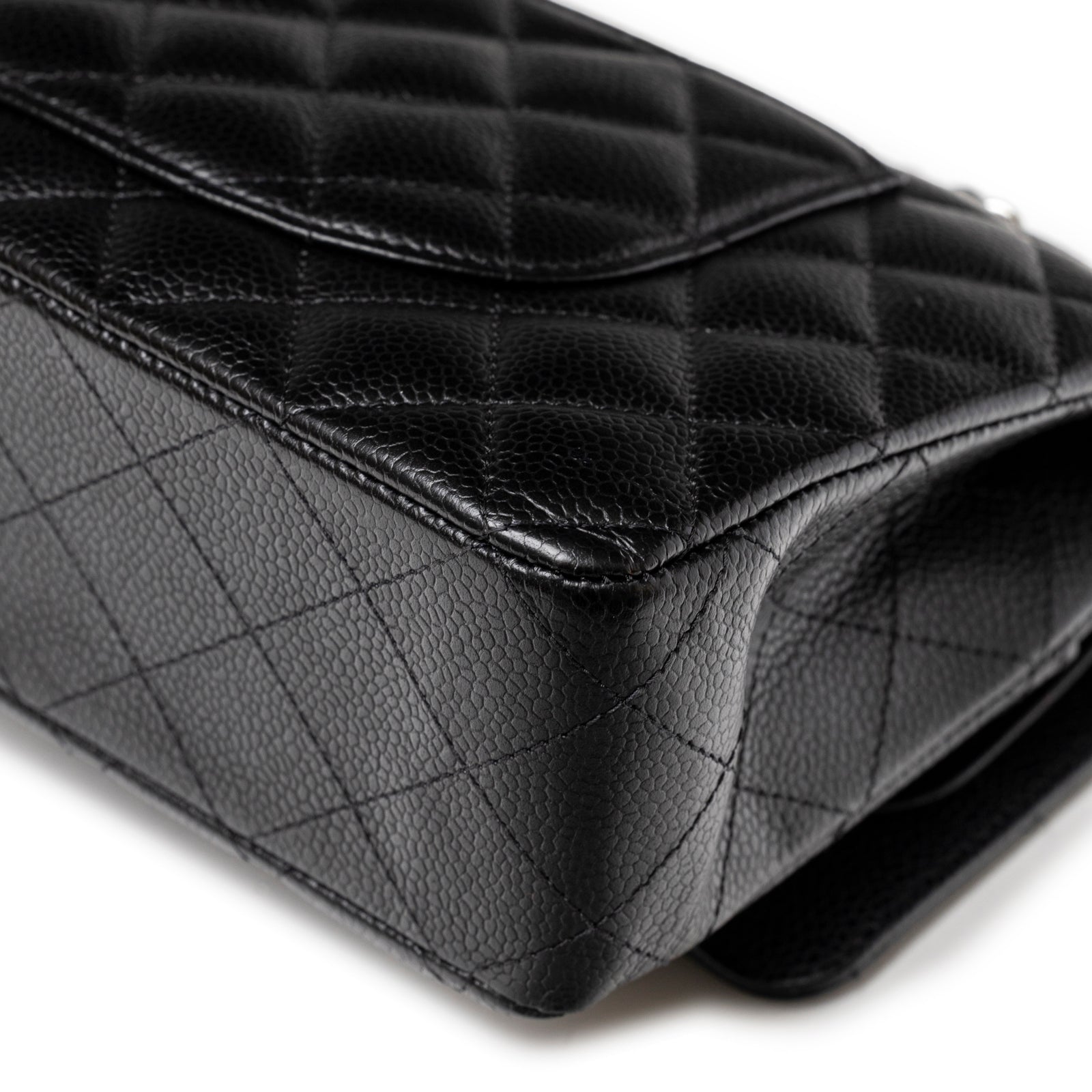 Close-up angled view of corner showing black caviar leather texture and quilted pattern on Chanel Medium Classic Flap Bag Black Caviar Palladium Hardware