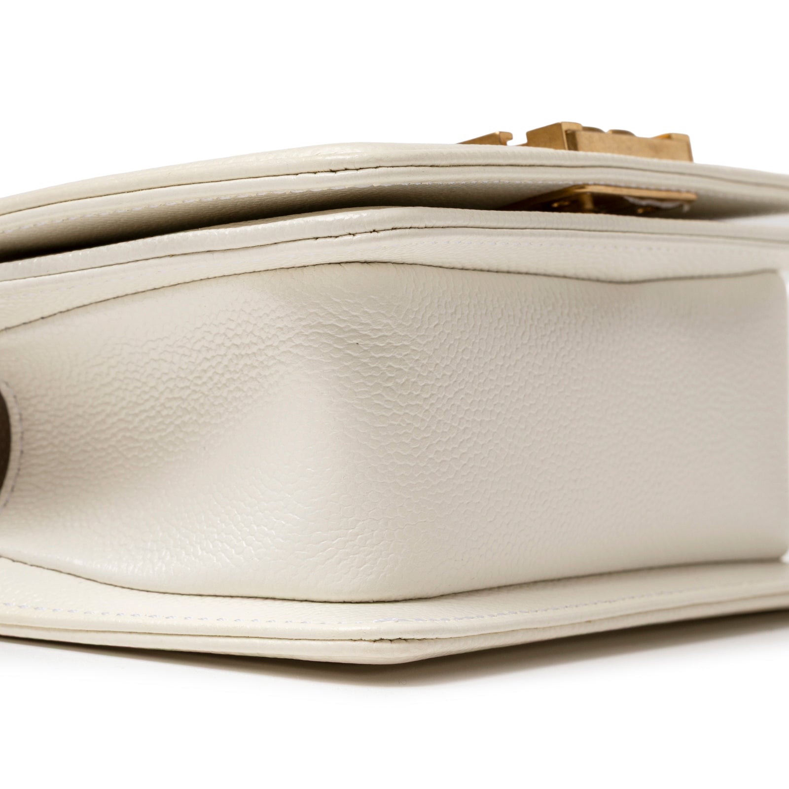 Close-up of bottom side detail showing textured white caviar leather and gold hardware on Chanel Mini Boy Bag White Caviar Gold Hardware