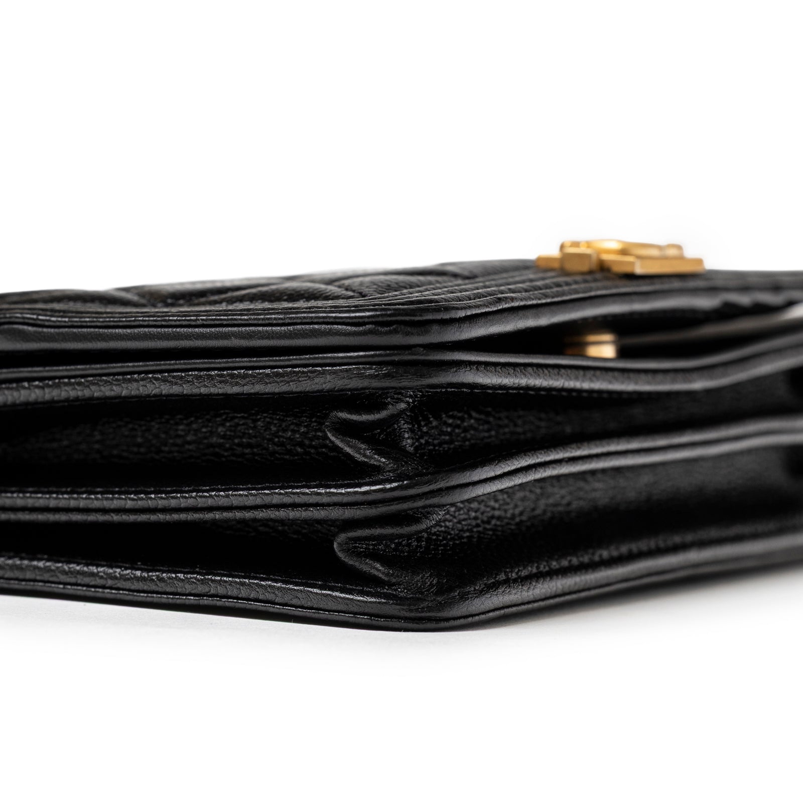 Layered side profile of Chanel Mini Boy Wallet on Chain Black Caviar Brushed Gold Hardware showing folded compartments and leather texture