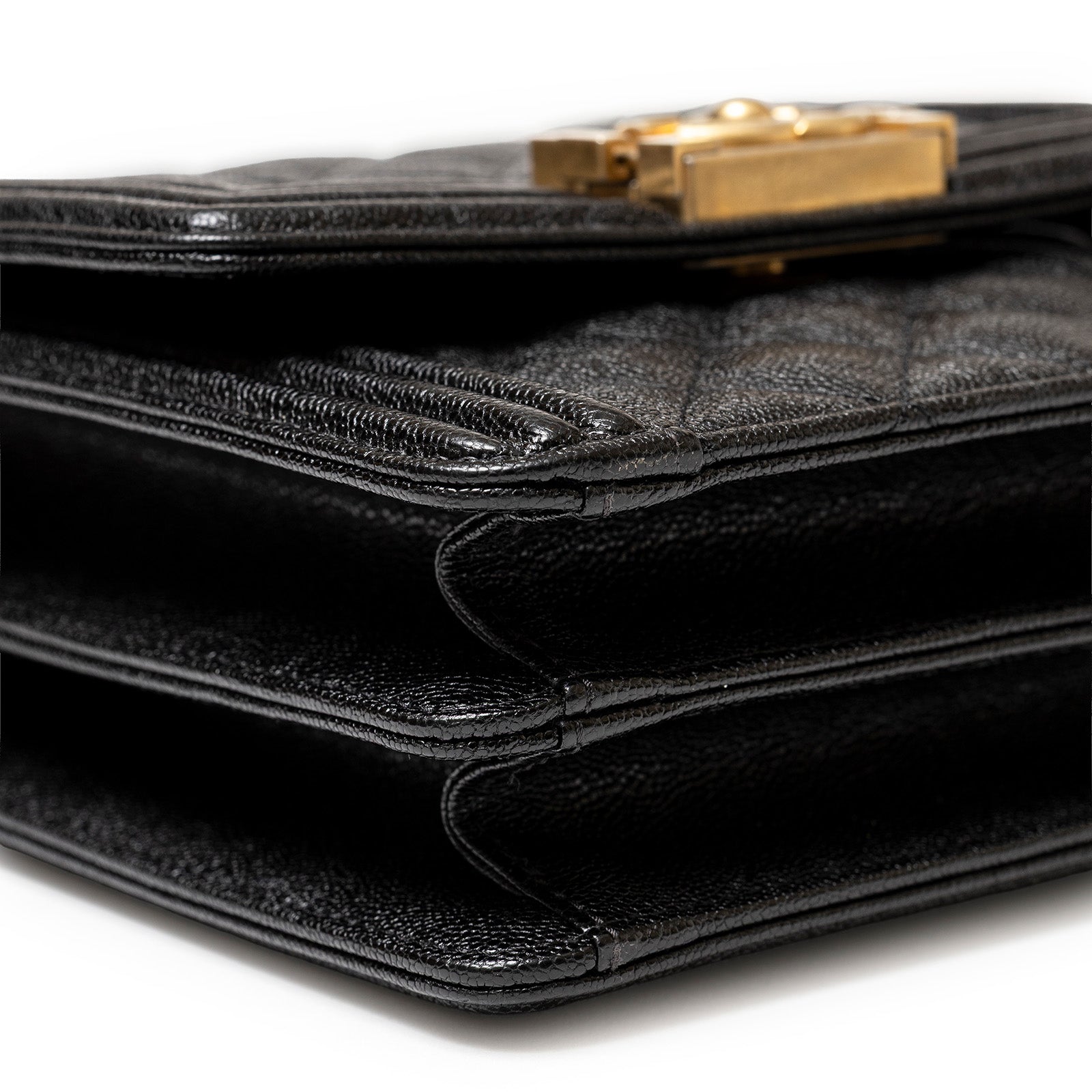Close-up angled shot of Chanel North South Boy Flap Bag Black Caviar Brushed Gold Hardware showing layered compartments and texture details.