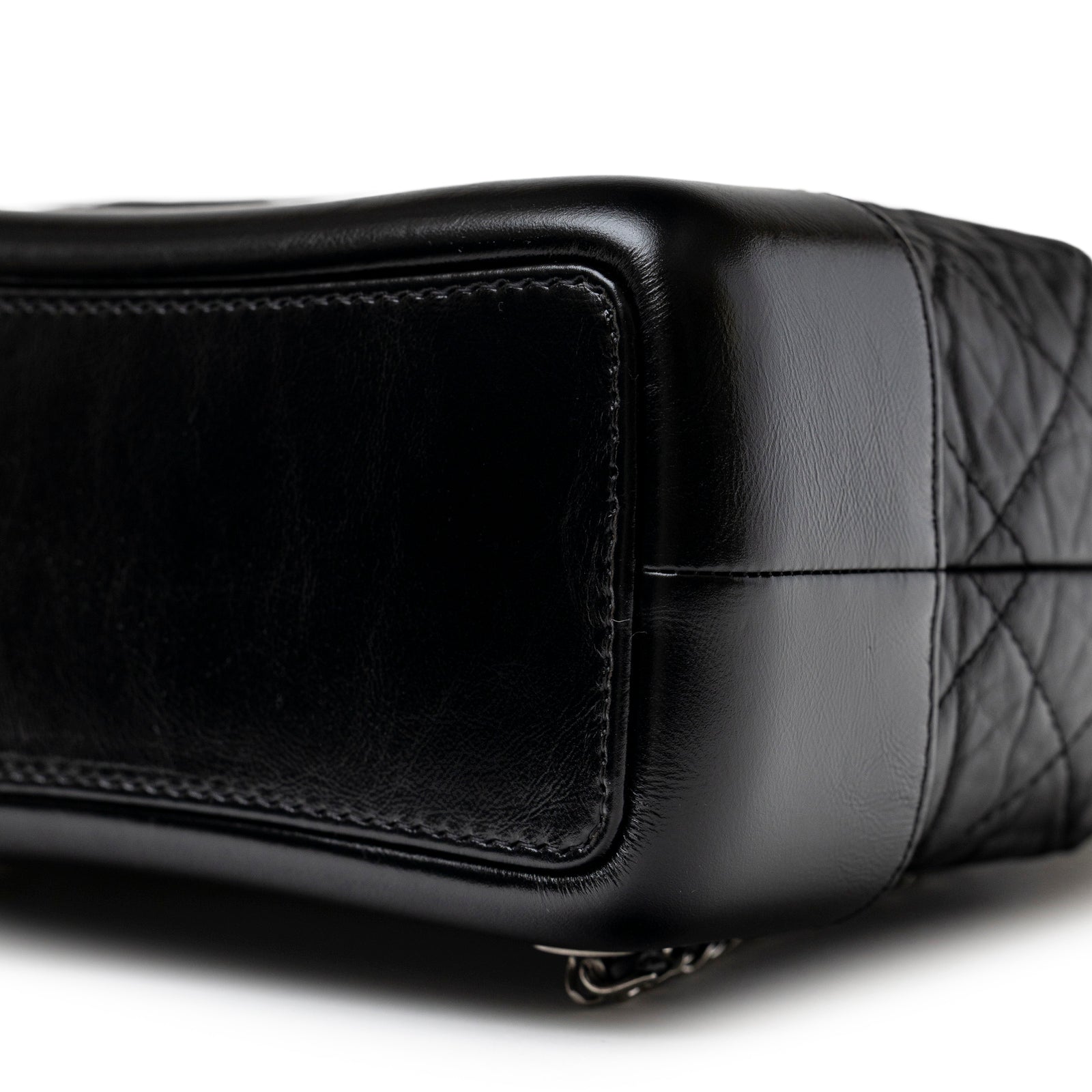 Close-up of the bottom corner showing black aged calfskin and mixed metal hardware on Chanel Small Gabrielle Backpack Black Aged Calfskin Mixed Metal Hardware