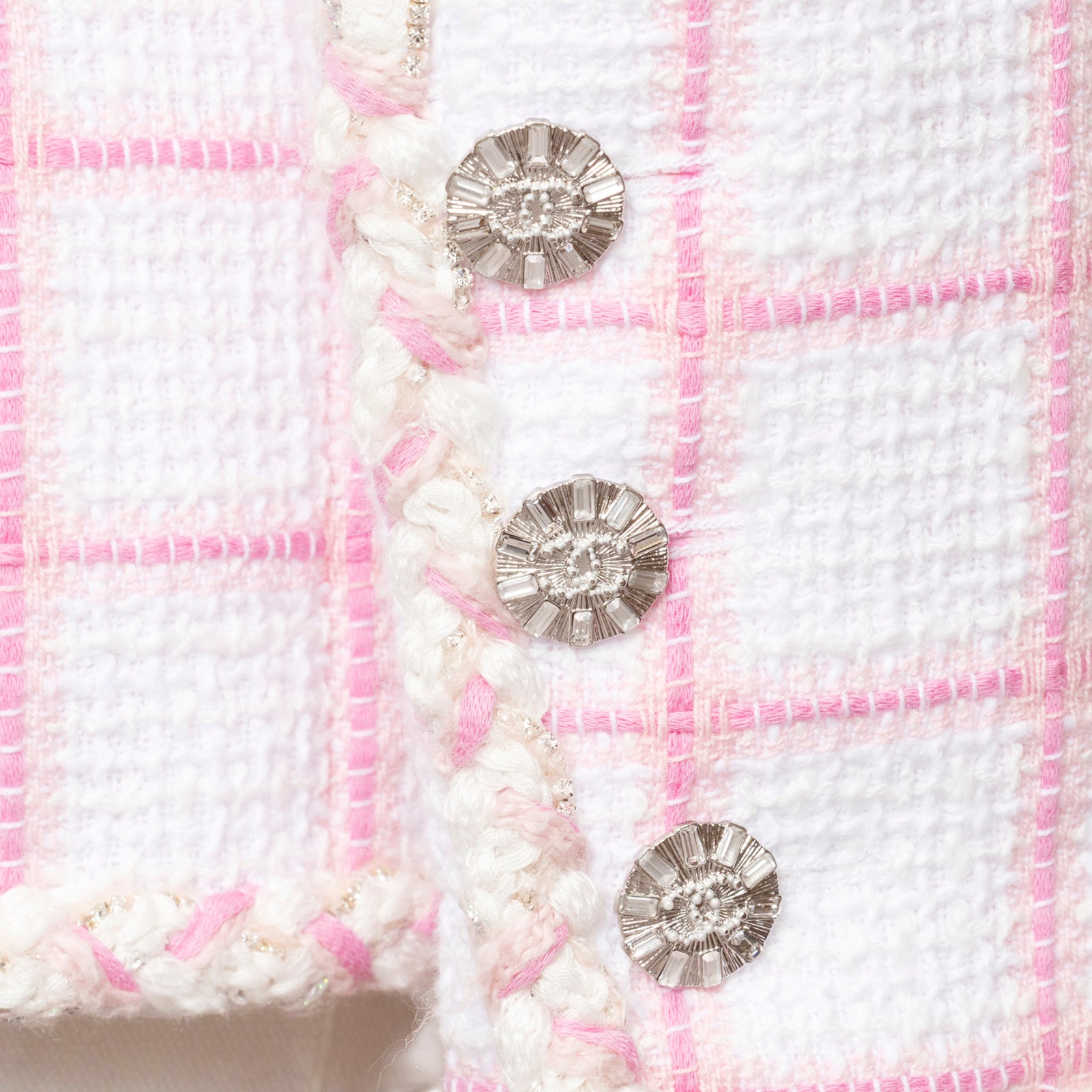 Close-up of silver buttons and textured fabric on Chanel Tweed Jacket 23C White/Pink with pink trim accents