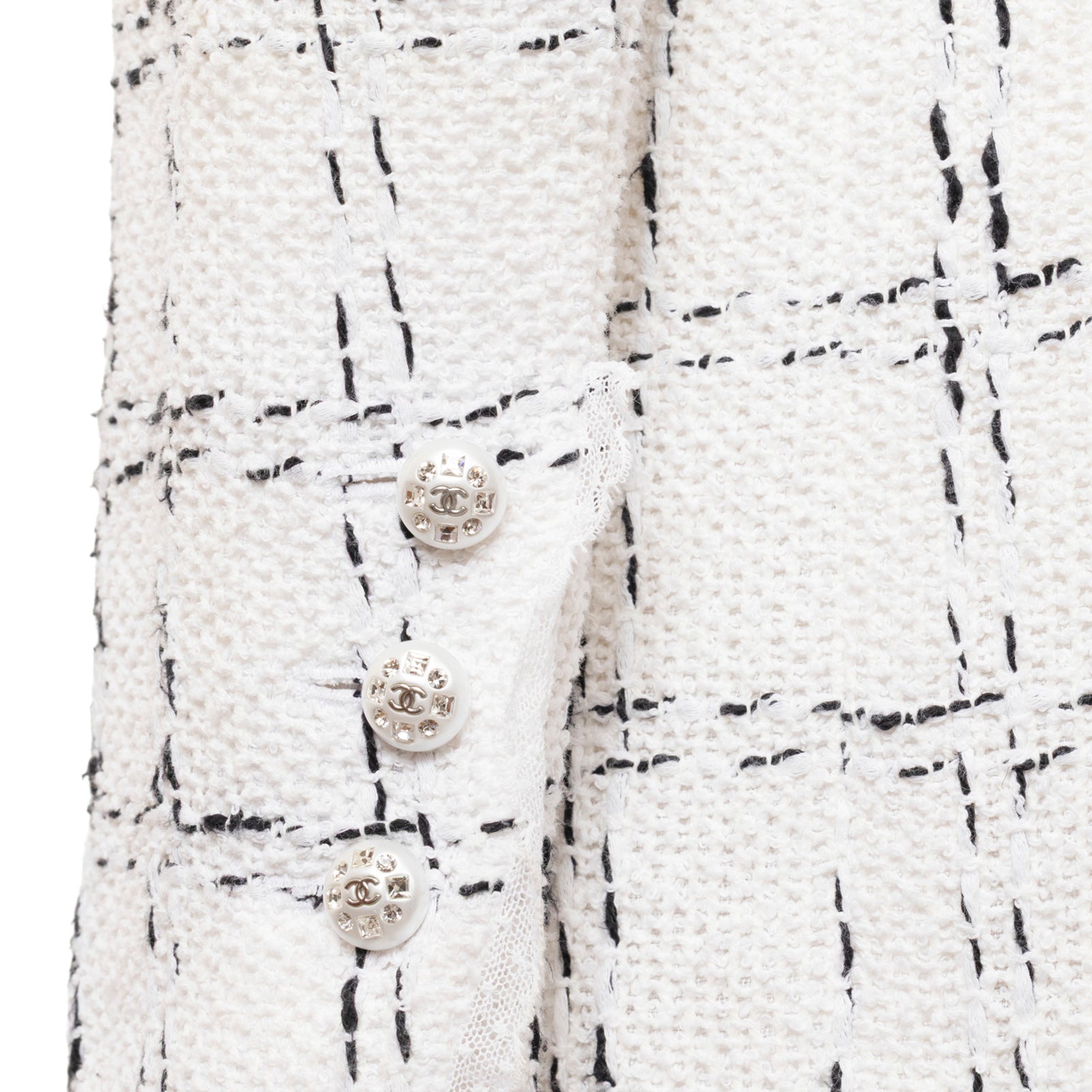 Close-up of Chanel Tweed Jacket 23S Pearl and Crystal Button White/Black sleeve showing detailed buttons and fabric texture