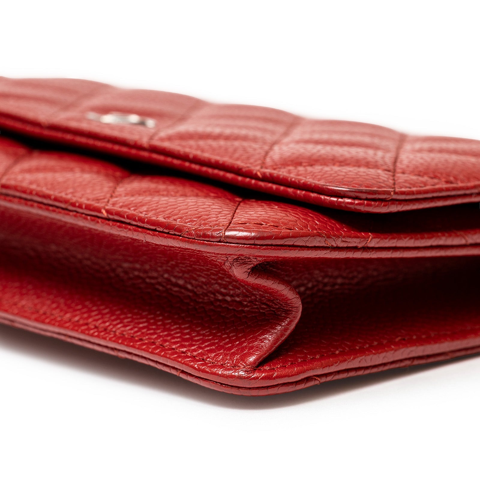 Close-up side view of Chanel Wallet On Chain Red Caviar Palladium Hardware showing textured leather and stitching detail