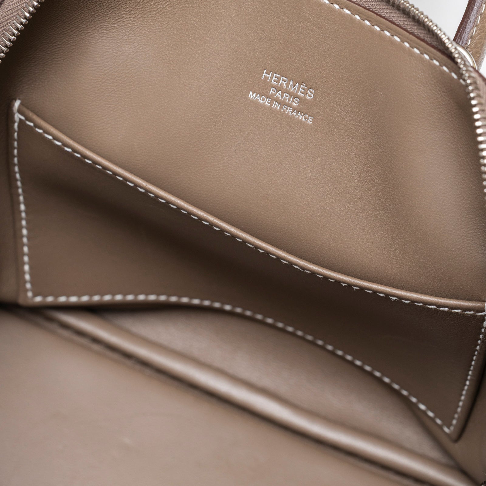 Close-up interior view of Hermès 1923 Bolide Mini Etoupe Evercolor Palladium Hardware leather pocket with logo stamp