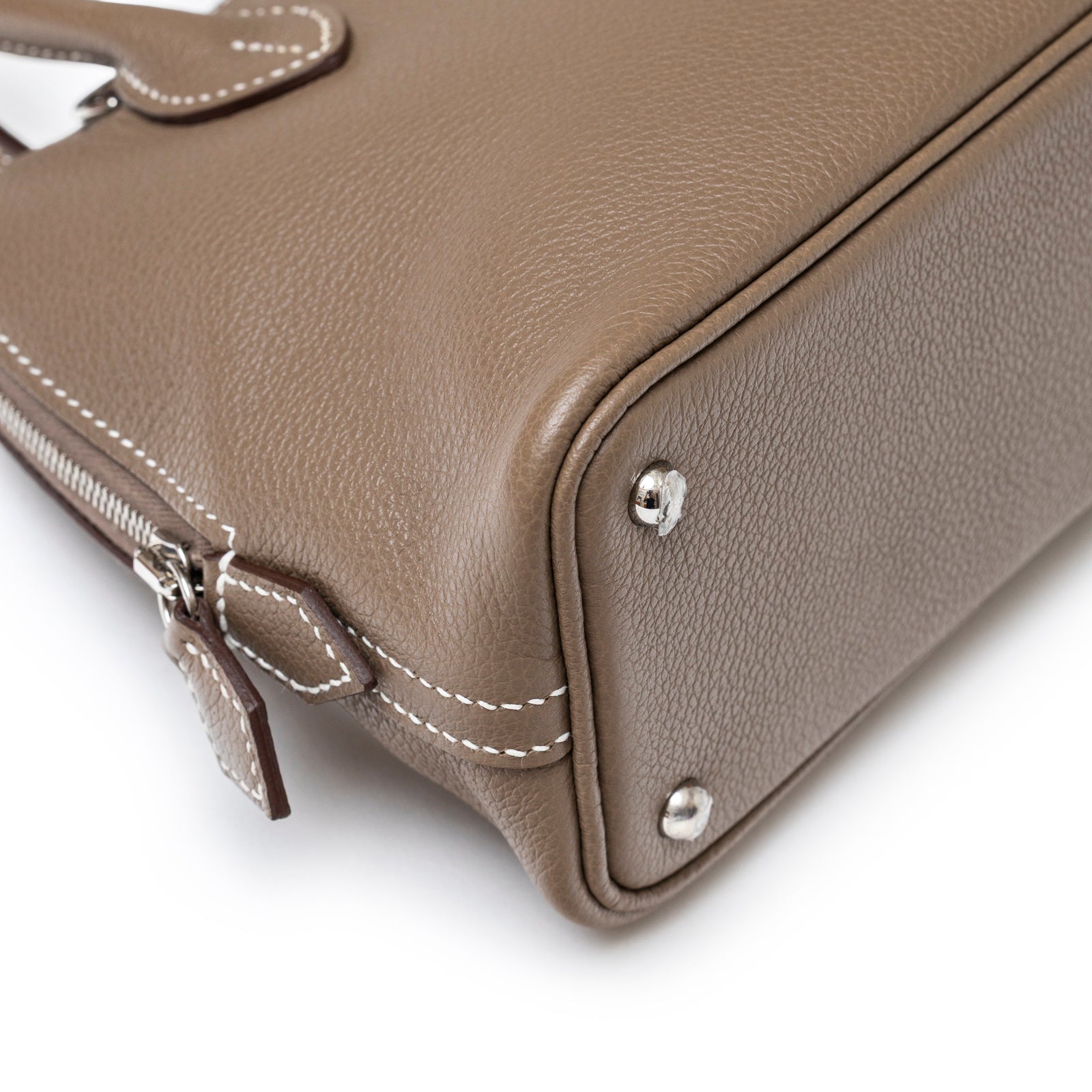 Close-up of bottom corner and zipper detailing on Hermès 1923 Bolide Mini Etoupe Evercolor Palladium Hardware bag