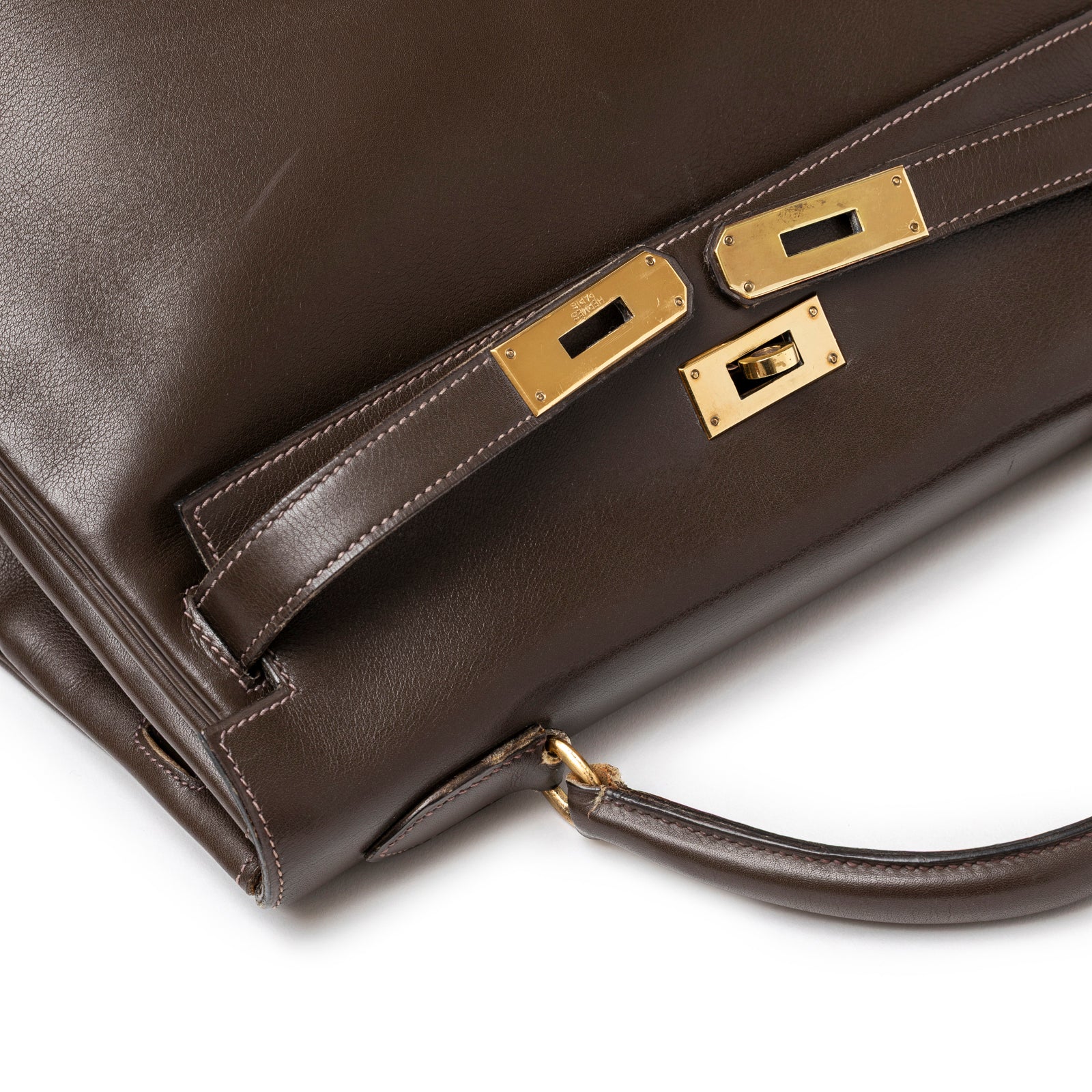 Close-up of gold hardware and leather strap details on Hermès 1974 Vintage Kelly 32 Marron Foncé Box Gold Hardware