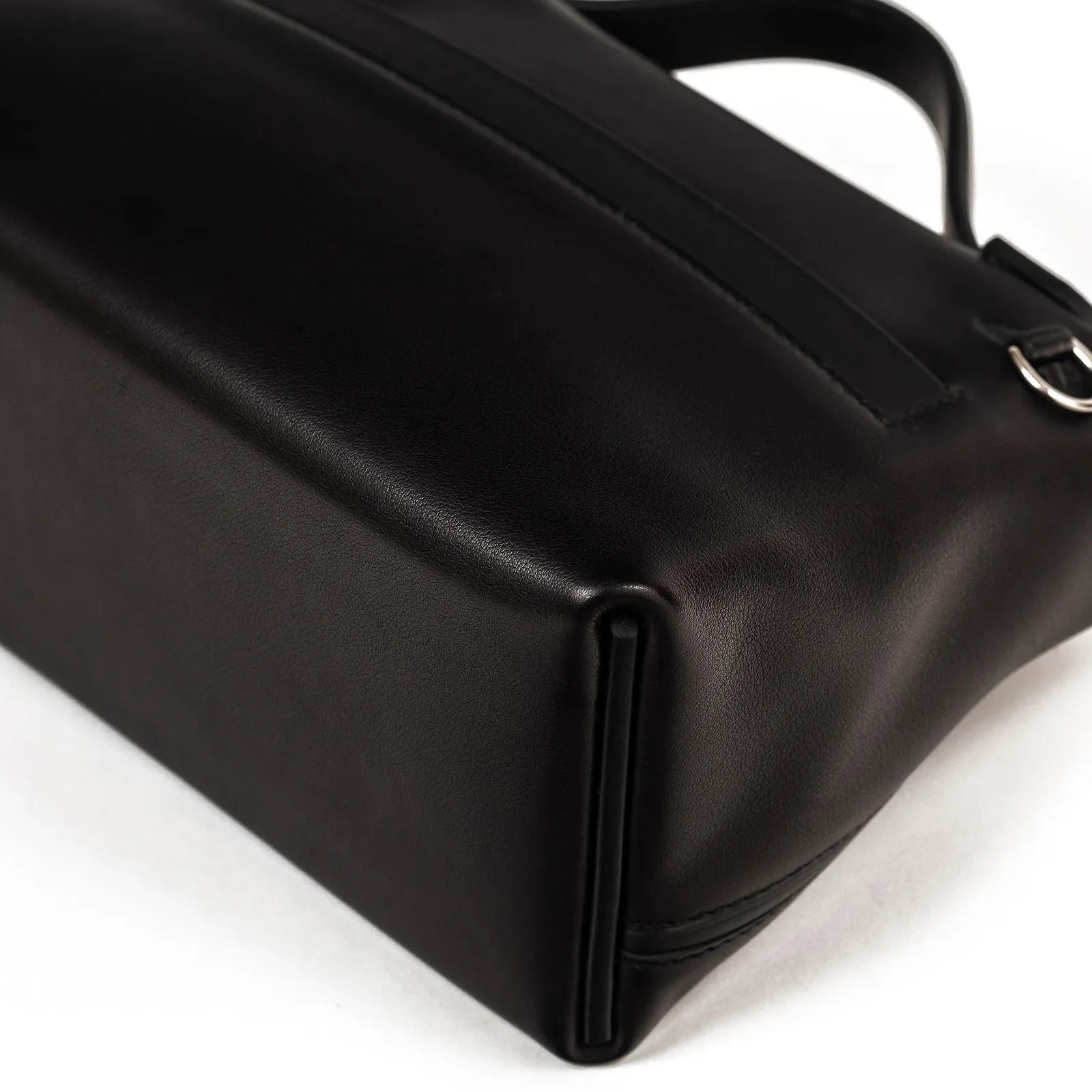 Close-up bottom view of black Hermès 24/24 21 handbag showing leather texture and stitching details