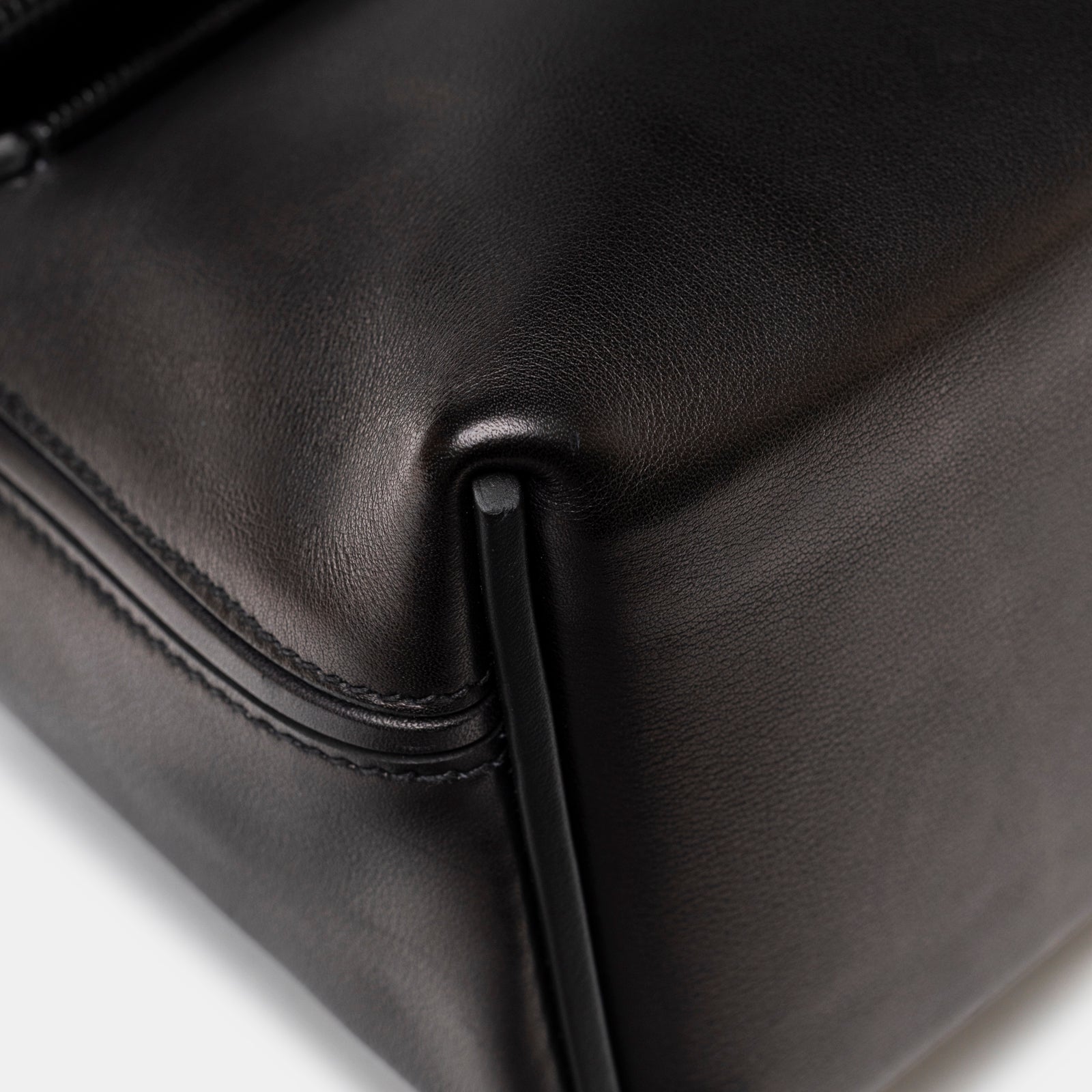 Close-up of smooth black leather corner and precise stitching on Hermès 24/24 21 Touch Black Lizard Volupto Gold Hardware bag
