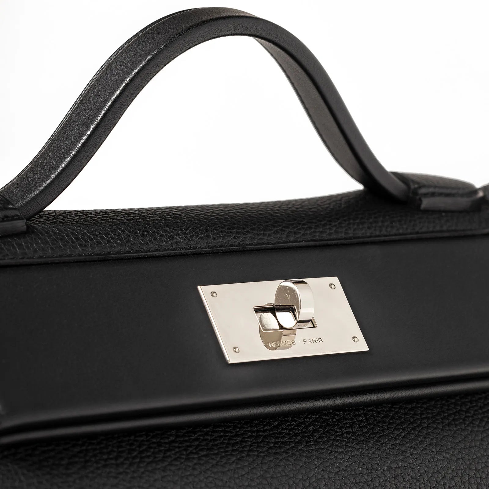 Close-up of black leather bag handle and palladium plated clasp with Hermès Paris engraving