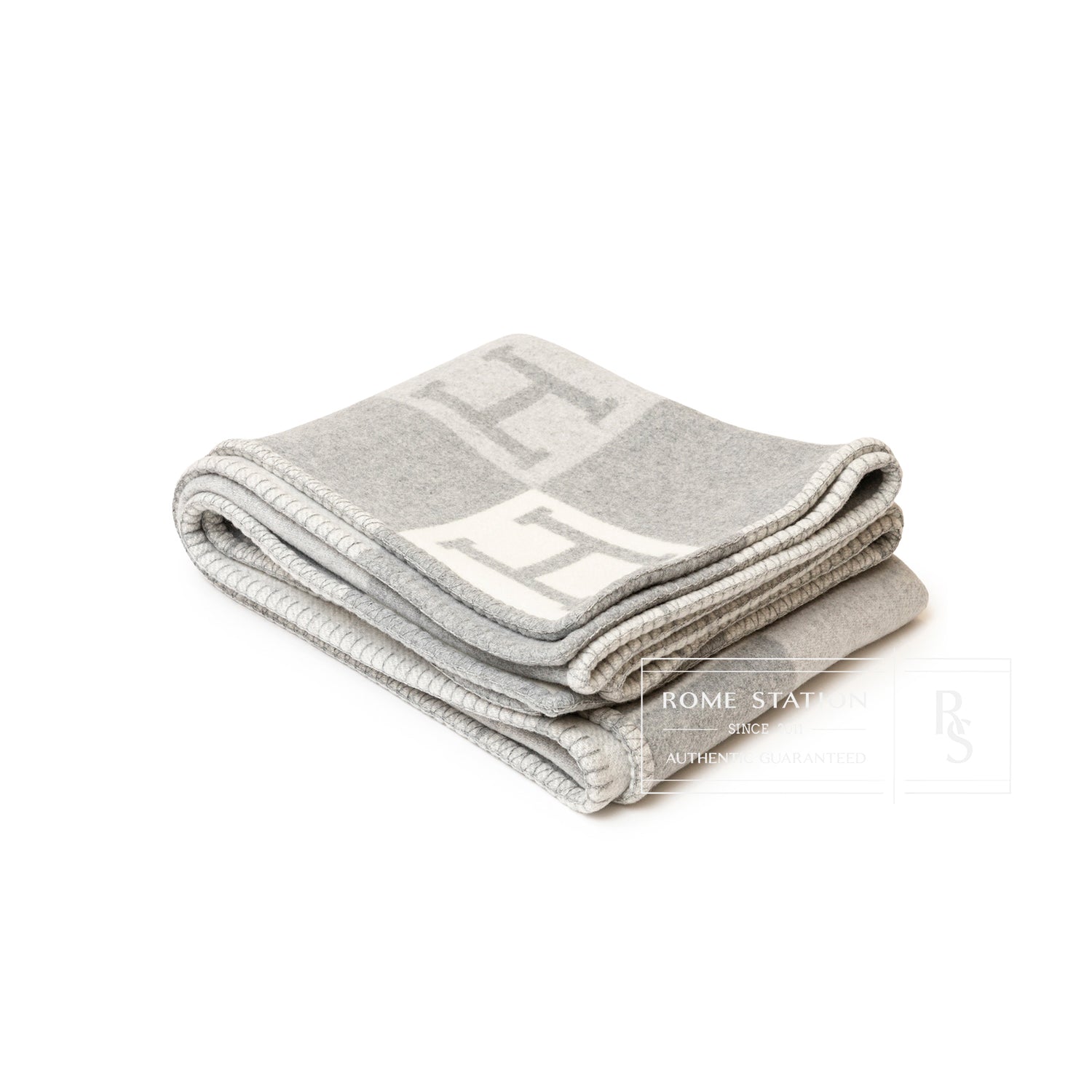 Soft folded Hermès Avalon Throw Blanket Ecru Gris Clair with subtle "H" pattern in light neutral shades