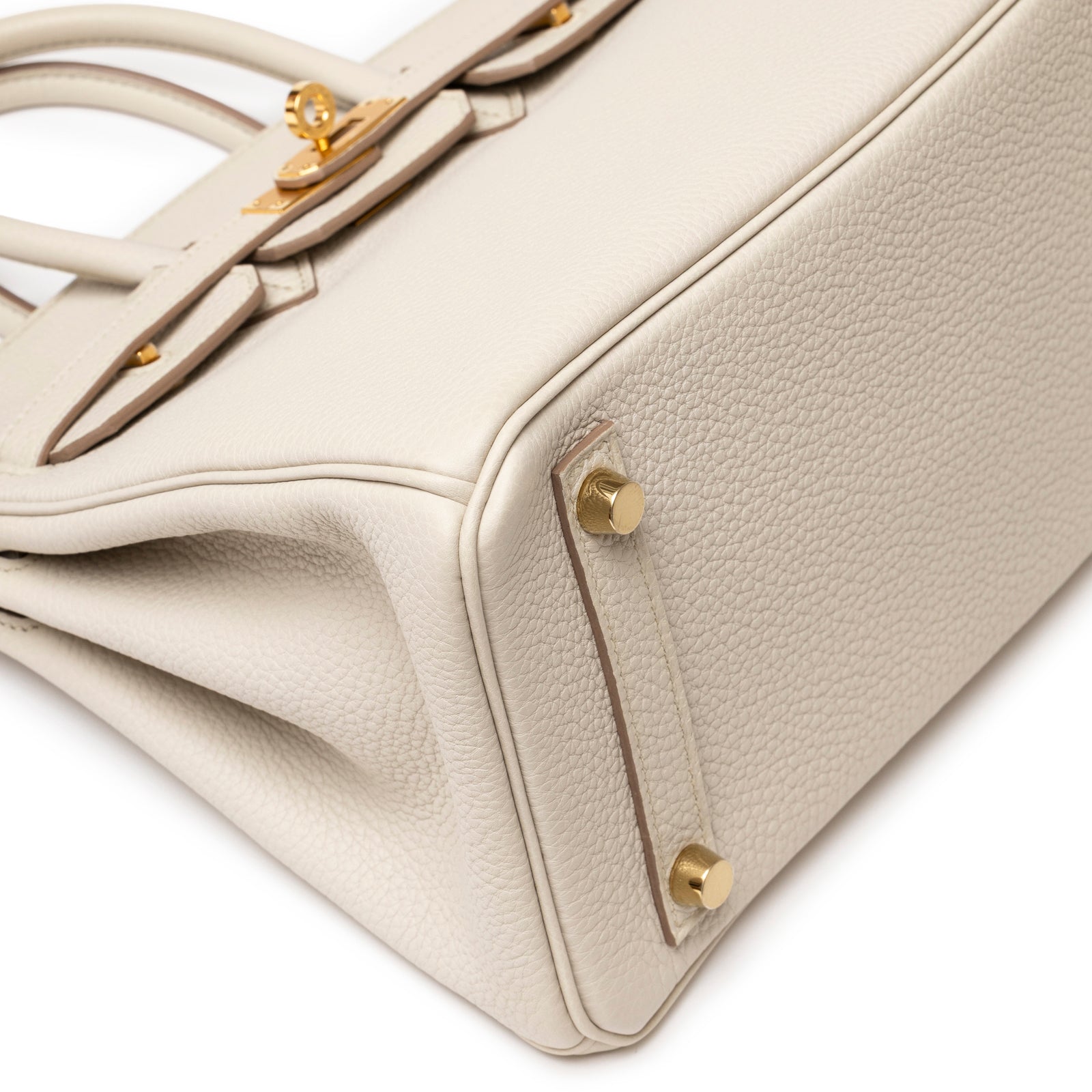 Close-up of bottom corner and gold hardware feet on Hermès Birkin 25 Beton Togo Gold Hardware handbag