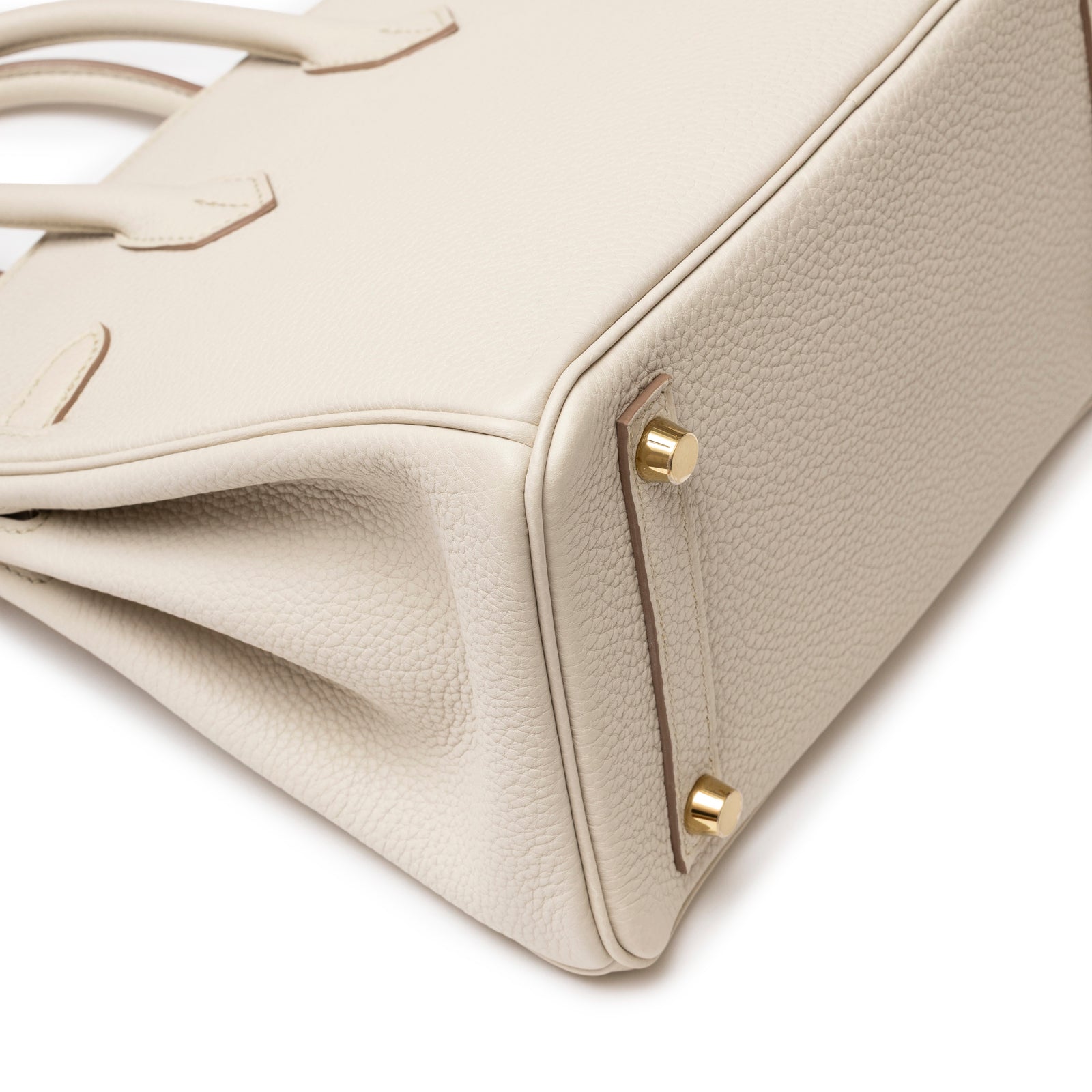 Close-up of bottom corner and gold hardware feet on Hermès Birkin 25 Beton Togo Gold Hardware handbag