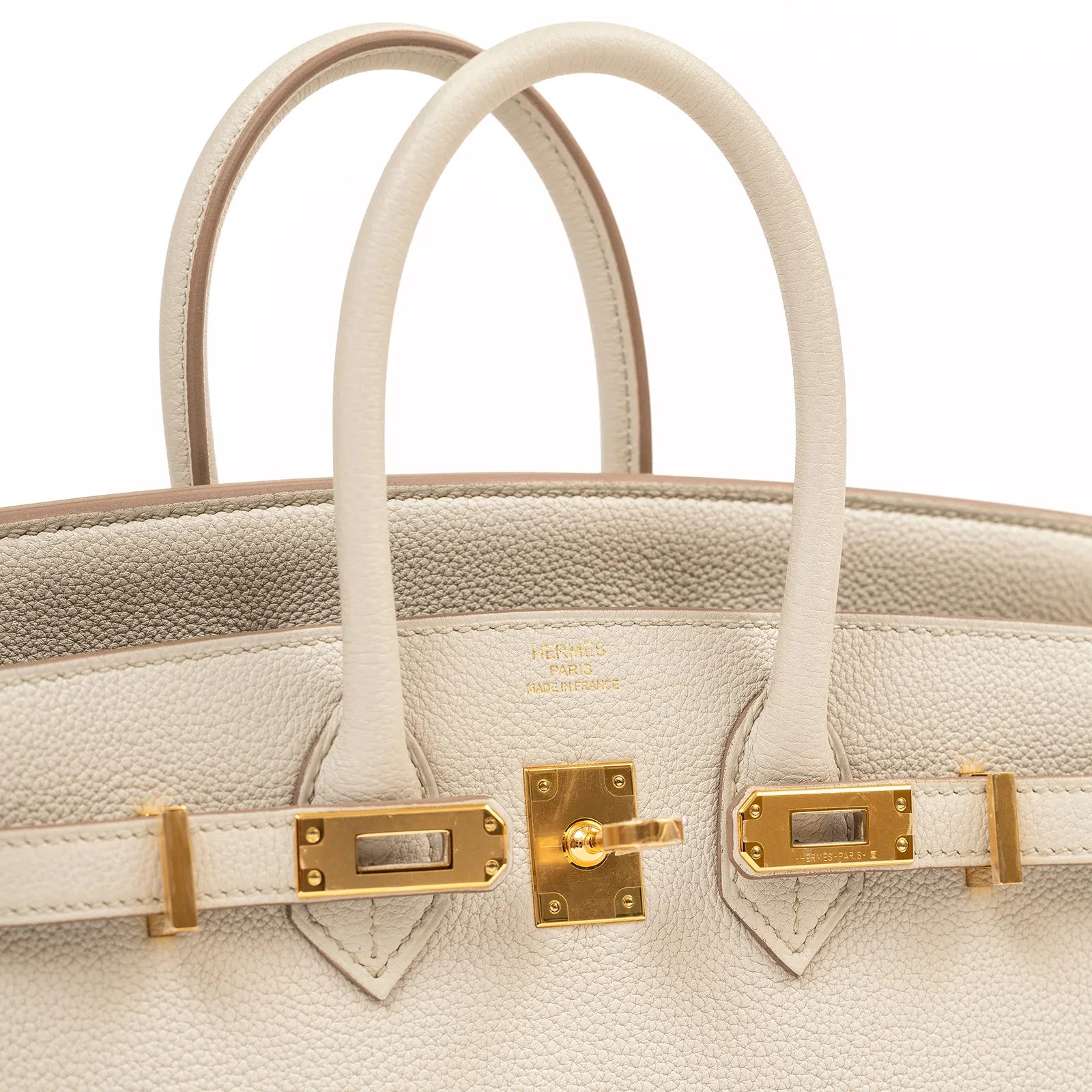 Close-up front view of Hermès Birkin 25 Beton Togo leather showcasing gold hardware and handles.