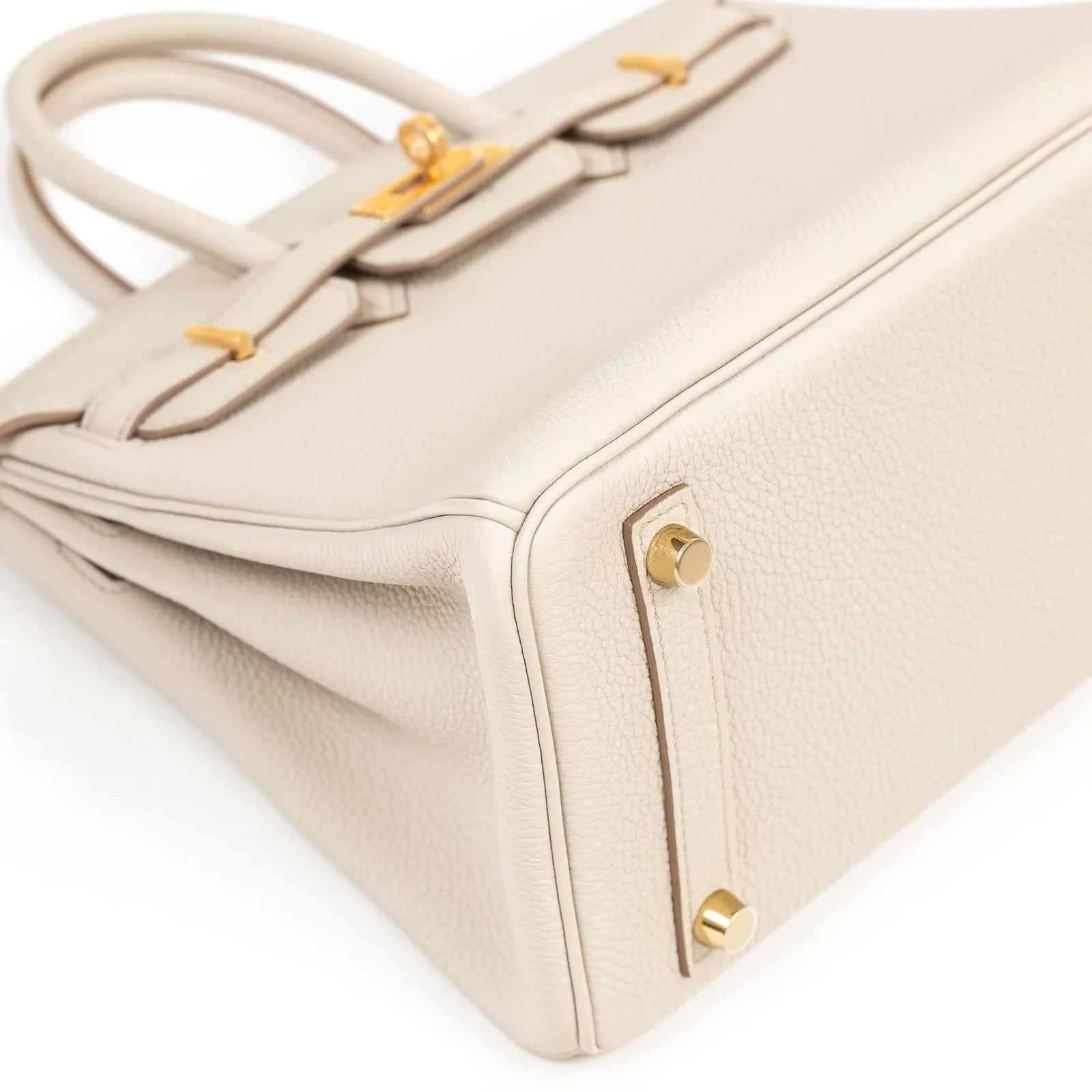 Angled close-up of Hermès Birkin 25 Beton Togo leather showing gold hardware and textured leather details.