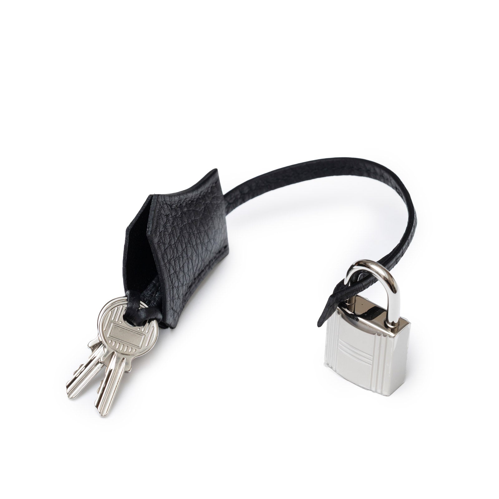 Close-up of Hermès Birkin 25 Black Togo Palladium Hardware lock and keys with leather strap detail on white background