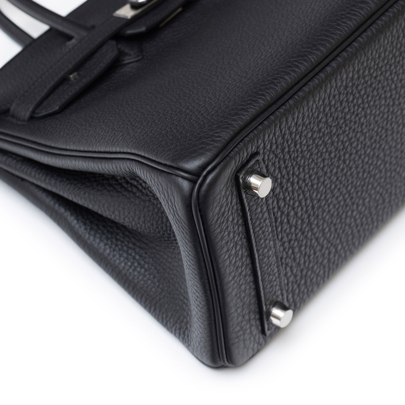 Close-up angled view of Hermès Birkin 25 Black Togo Palladium Hardware showcasing leather texture and metal feet details