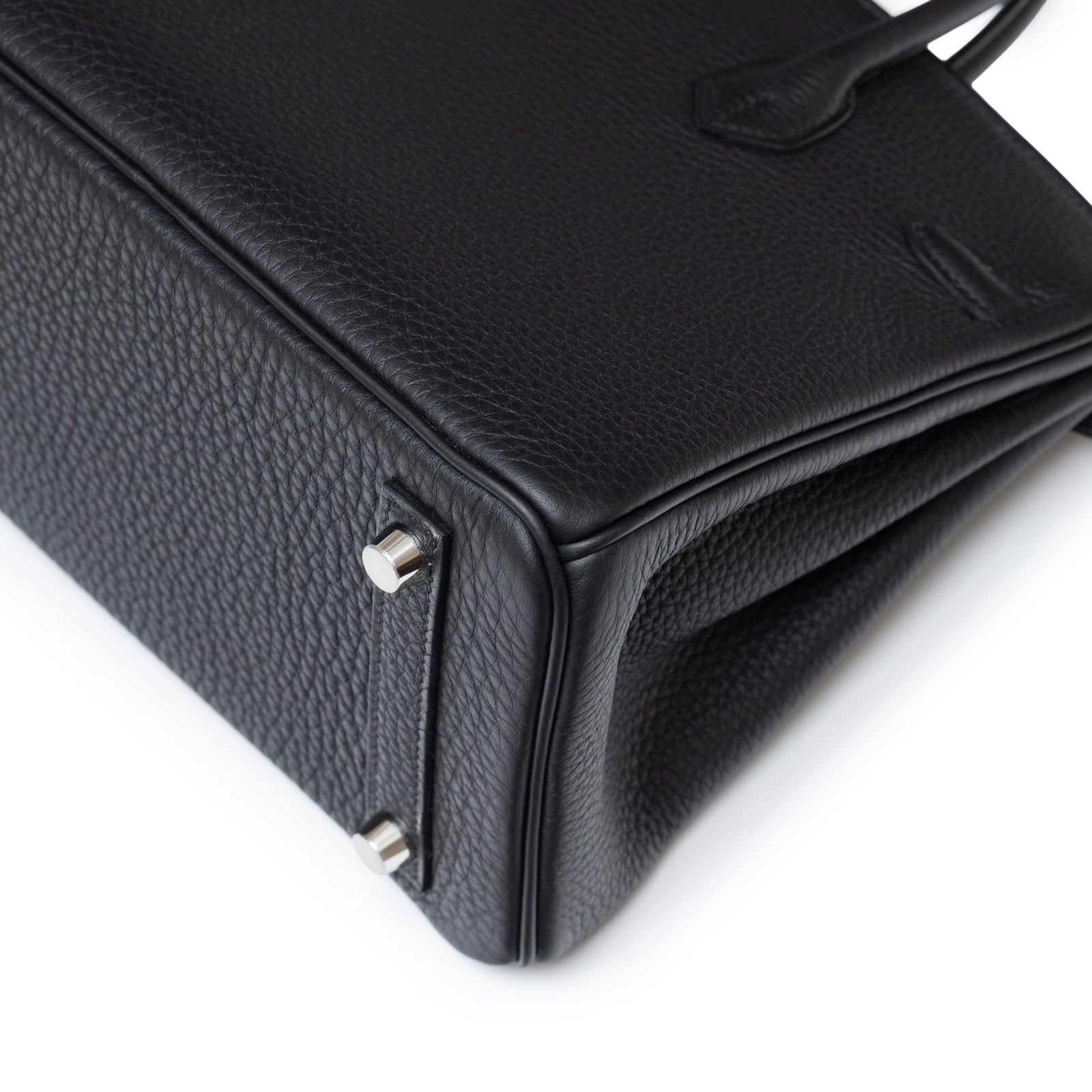 Close-up angled shot of Hermès Birkin 25 Black Togo Palladium Hardware showing leather grain and base studs.