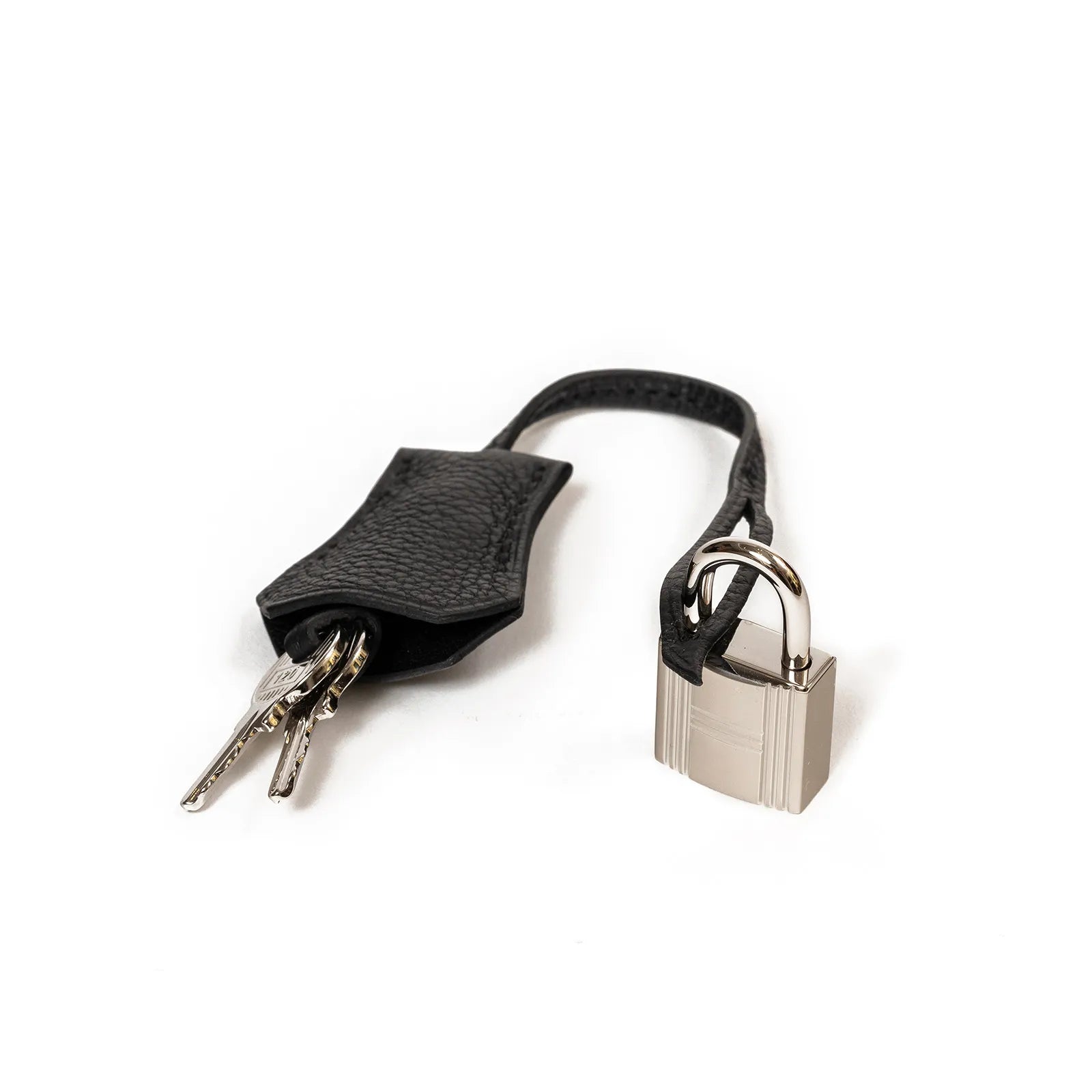 Close-up of black leather clochette with two keys and palladium padlock for handbag accessory