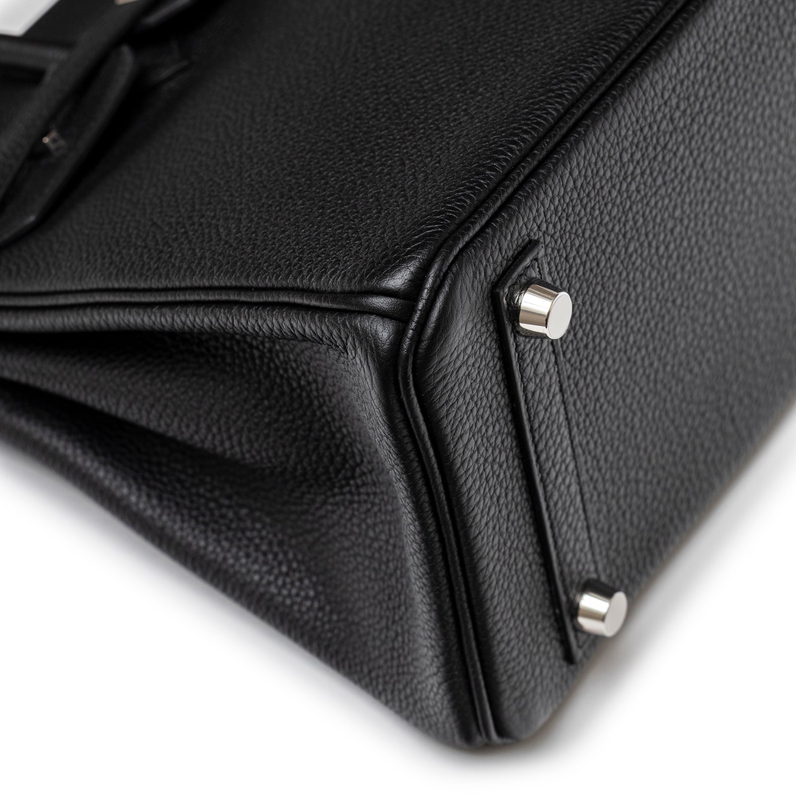 Close-up of the base showing fine grained black leather and polished palladium feet on Hermès Birkin 25 Black Togo Palladium Hardware