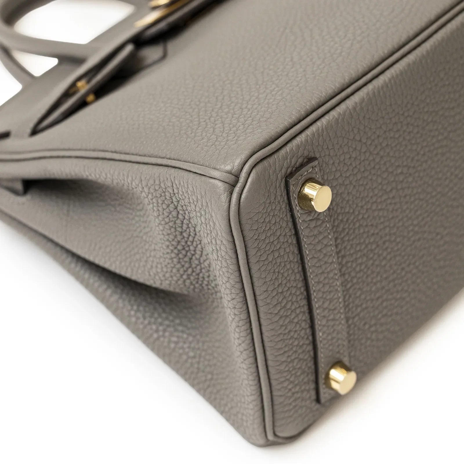 Close-up angled view of Birkin 25 Gris Meyer Togo leather showing gold feet and textured corner detailing