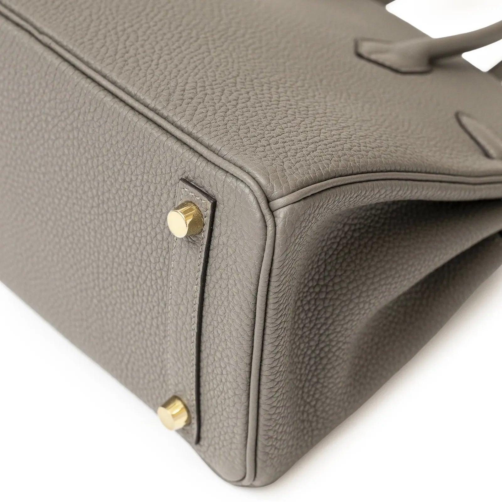 Close-up of Hermès Birkin 25 Gris Meyer togo leather corner with gold hardware feet and detailed stitching