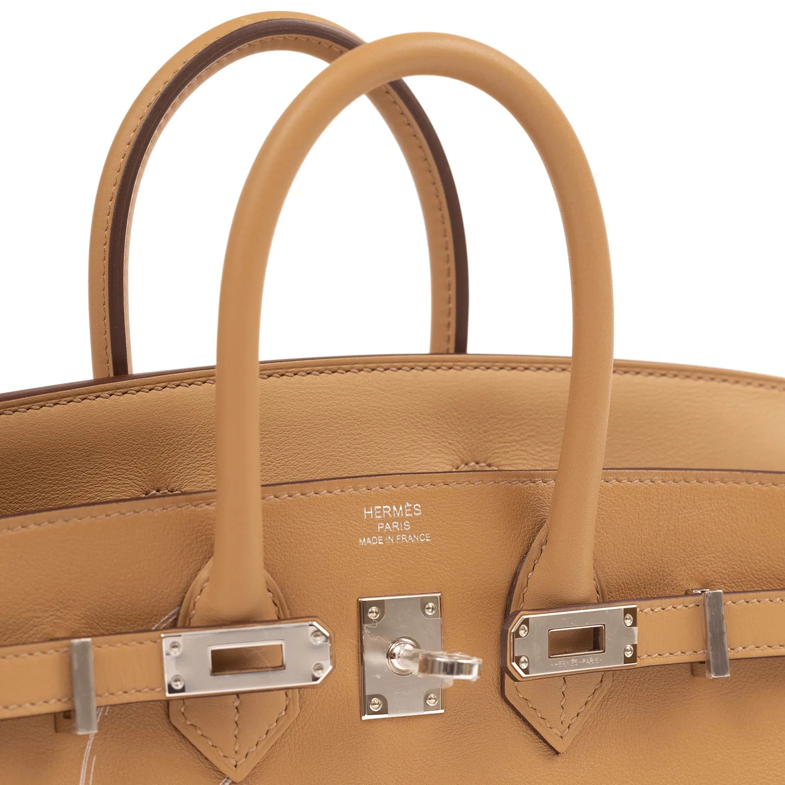 Close-up of Hermès Birkin 25 biscuit leather handles and palladium hardware showing logo embossing and strap details