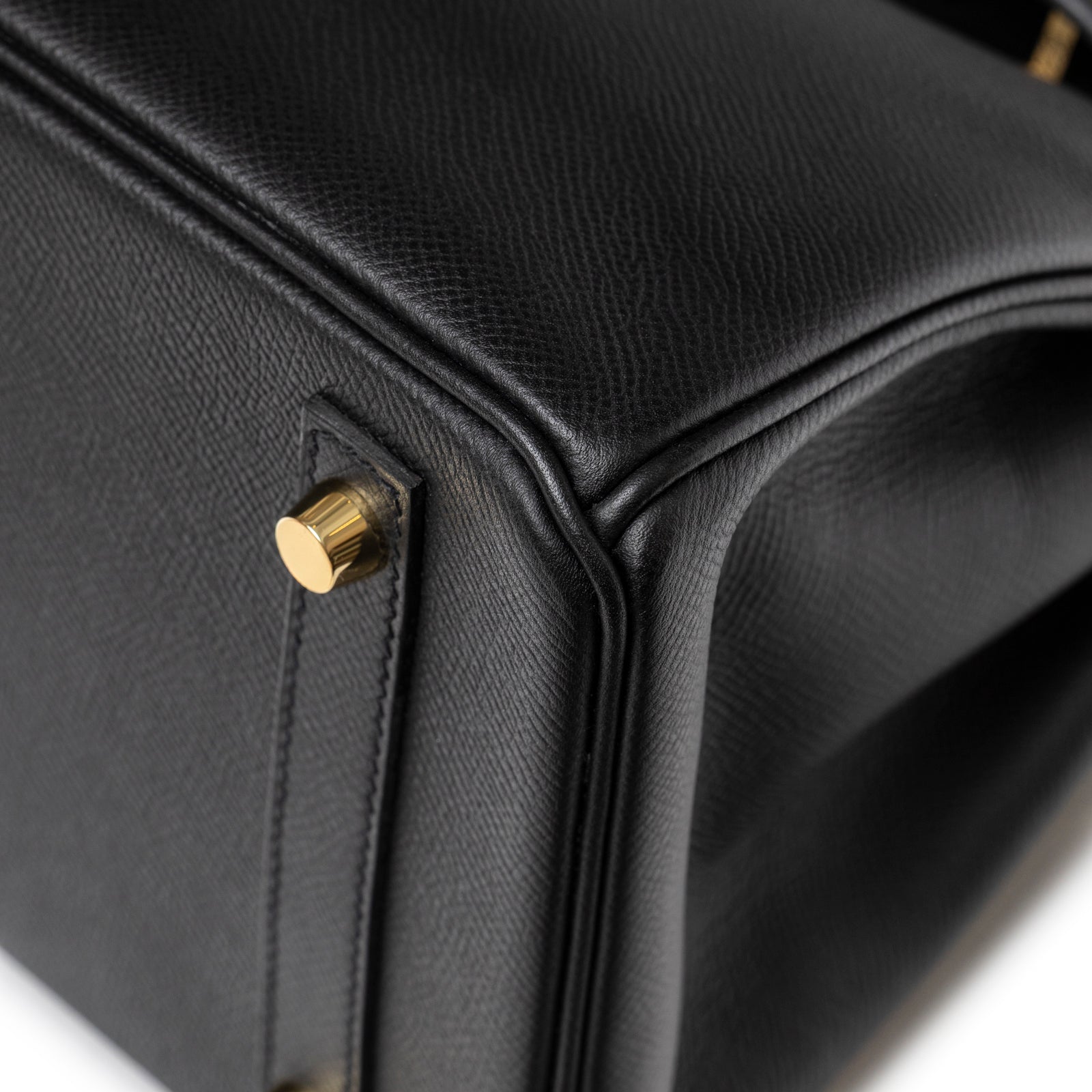 Close-up of bottom corner on Hermès Birkin 30 Black Epsom Gold Hardware highlighting textured leather and gold stud protection