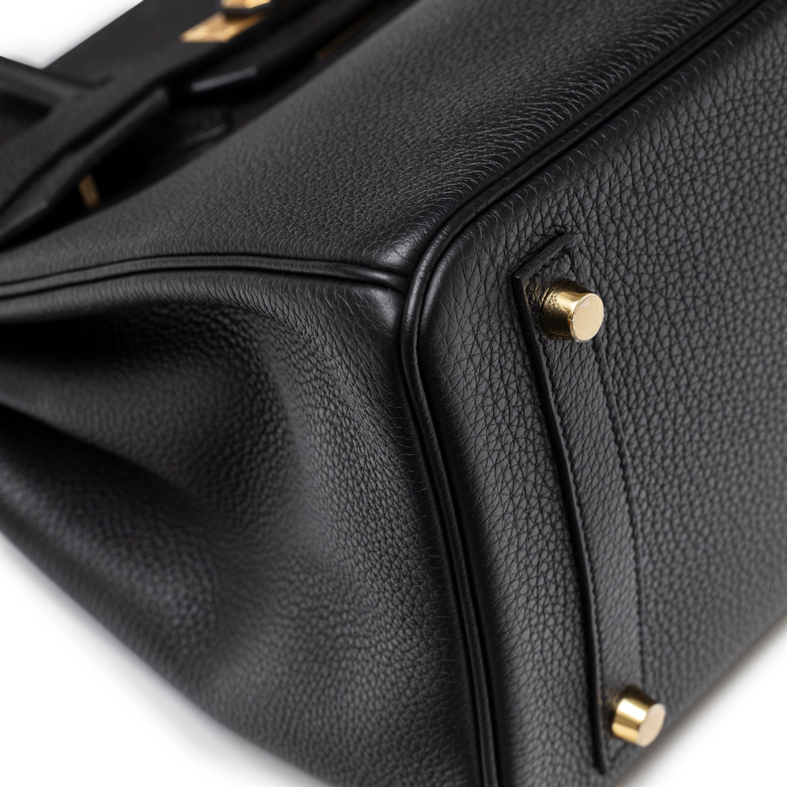 Close-up of bottom corner showing grainy texture and gold feet on Hermès Birkin 30 Black Togo Gold Hardware