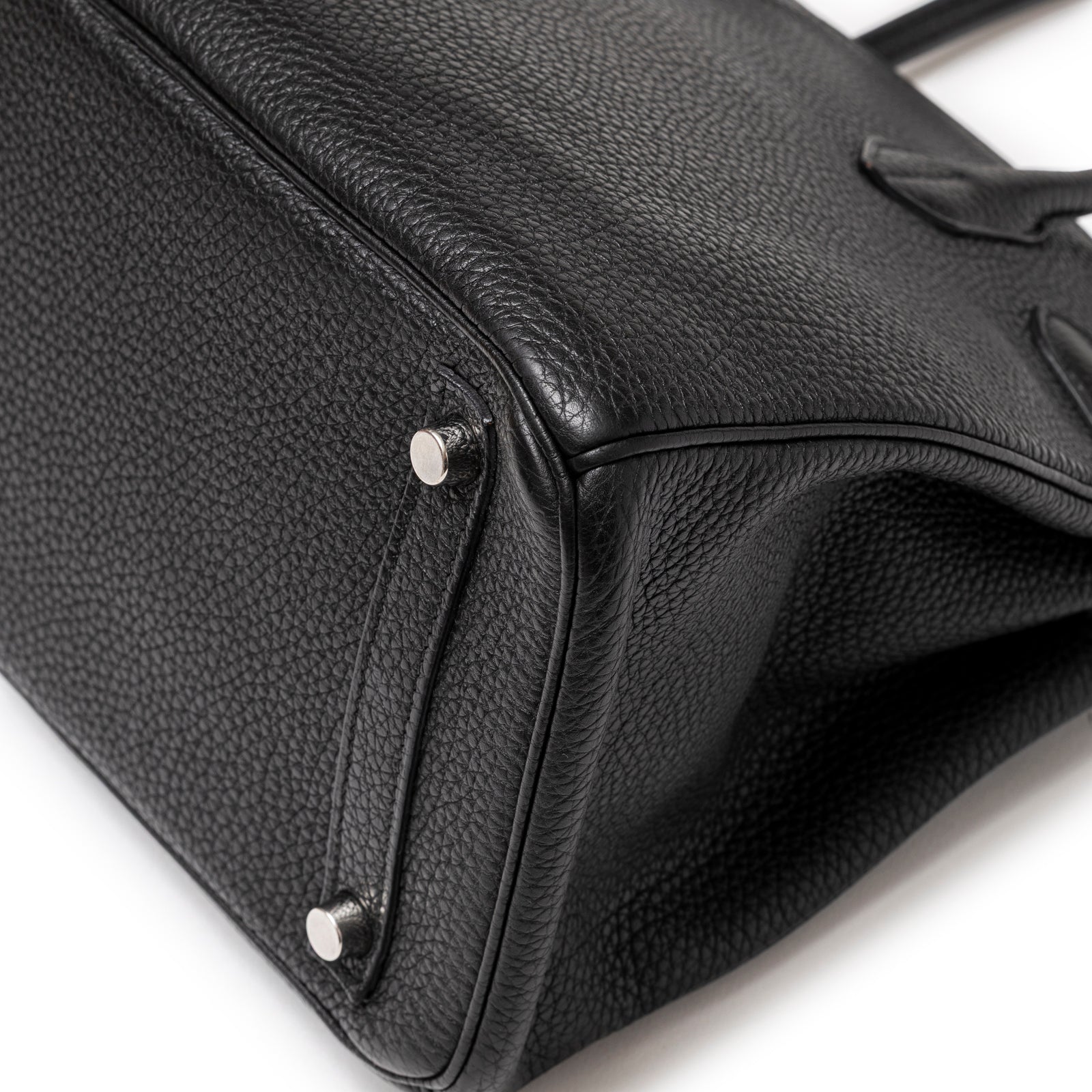 Close-up of base corner showing textured leather and palladium hardware feet on Hermès Birkin 30 Black Togo Palladium Hardware