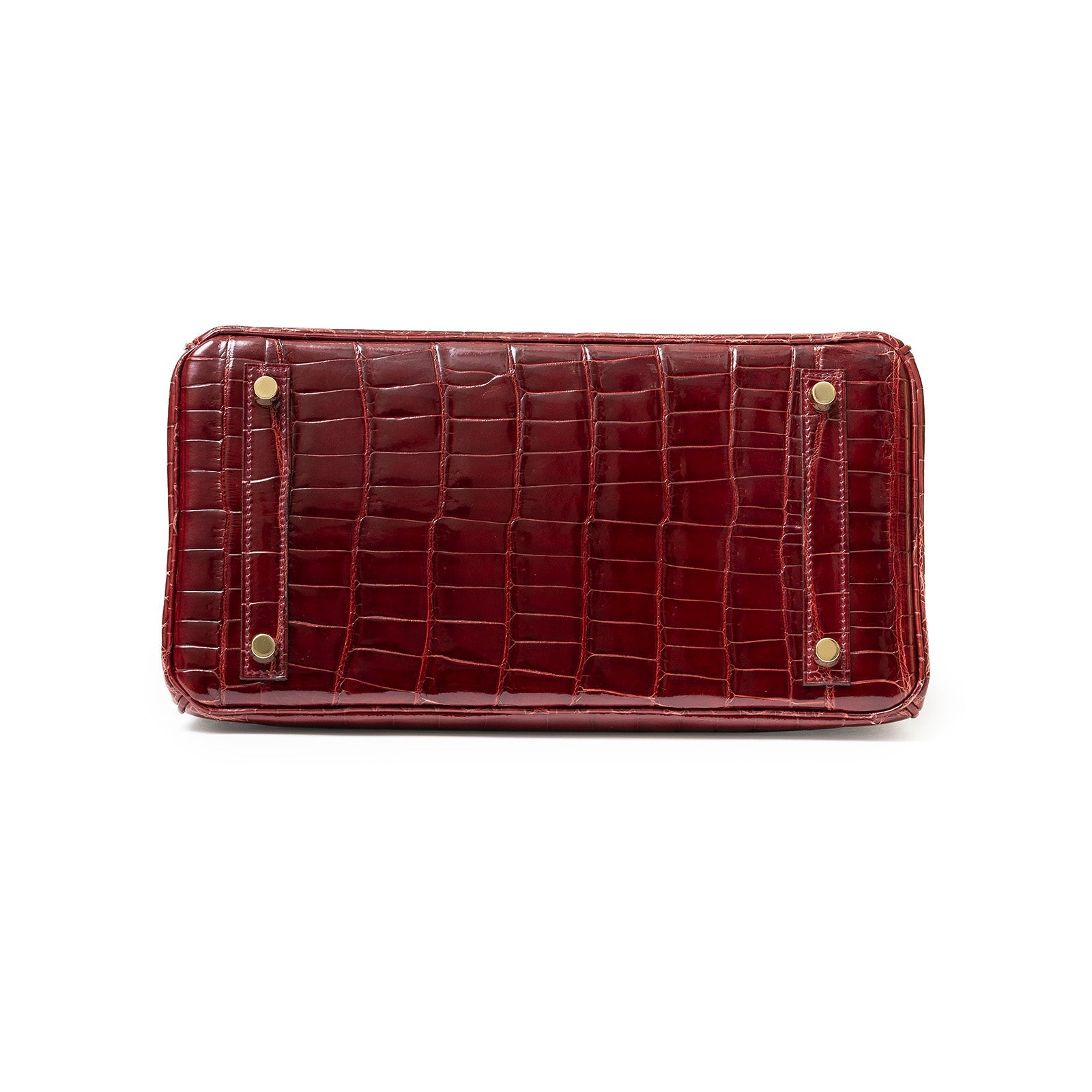 Bottom view of Hermès Birkin 30 in shiny Bourgogne Niloticus crocodile with gold hardware feet visible