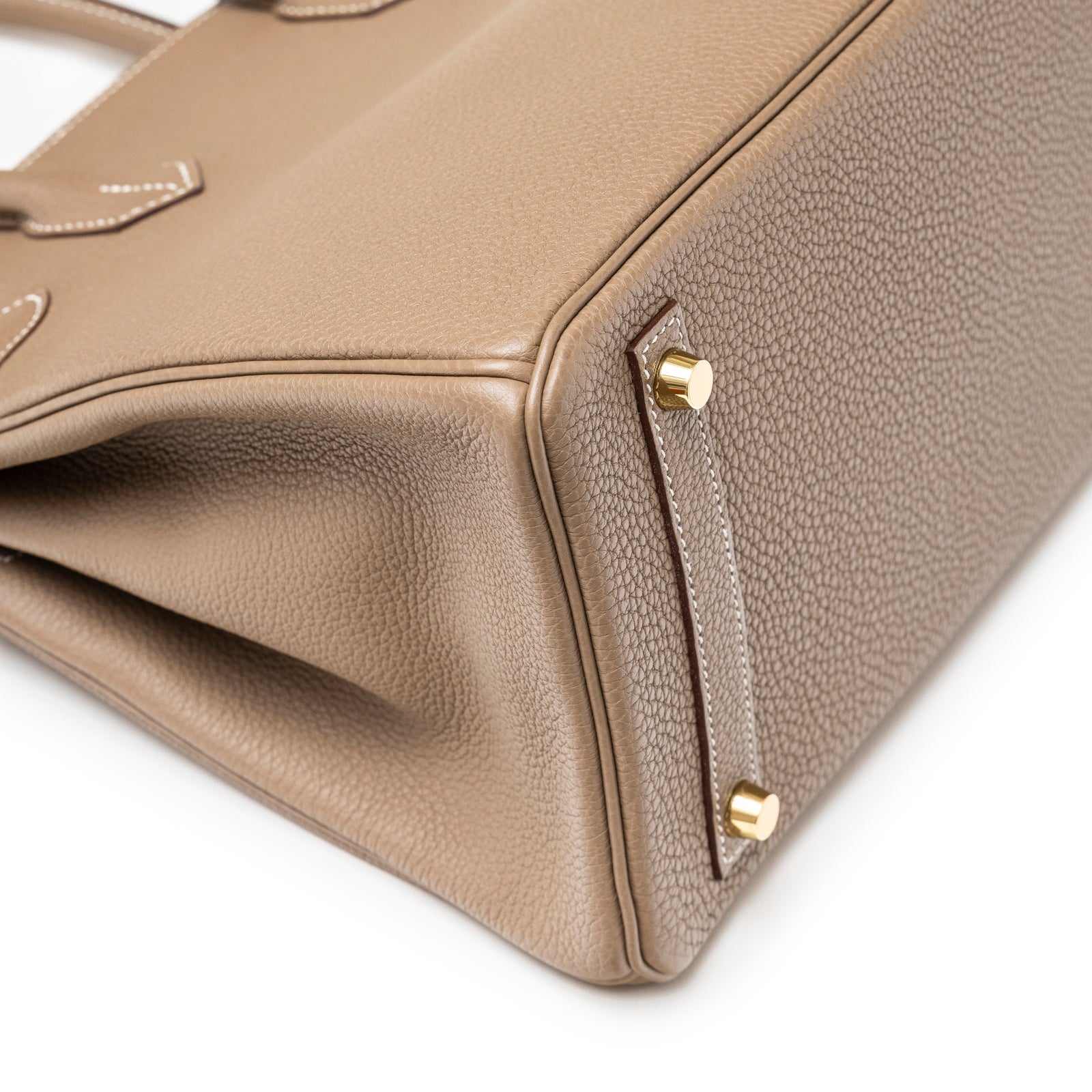 Close-up angled view of Hermès Birkin 30 Etoupe Togo Gold Hardware showing textured leather and gold studs on base