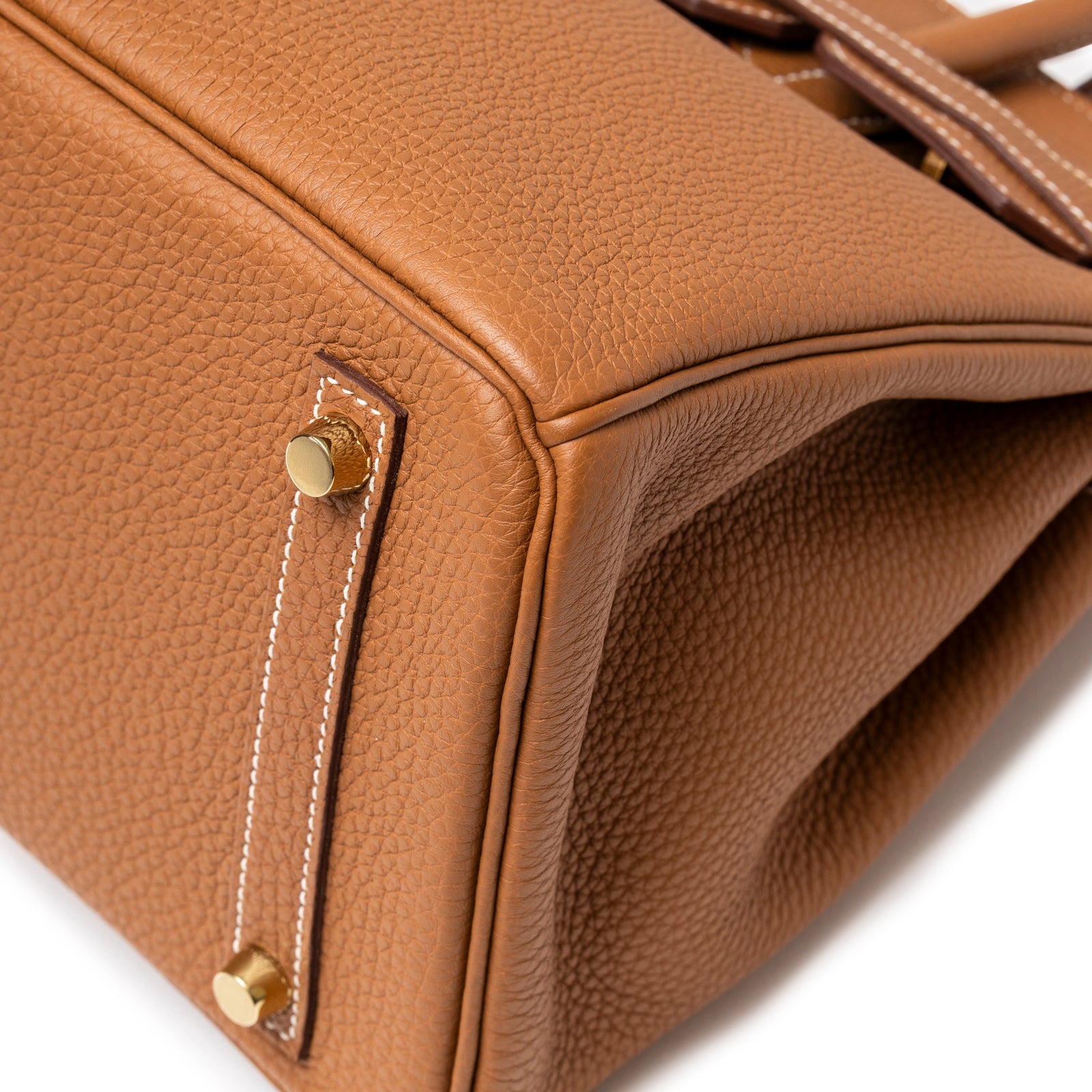 Close-up of Hermès Birkin 30 Gold Togo Gold Hardware showing textured leather corner and protective gold feet details.