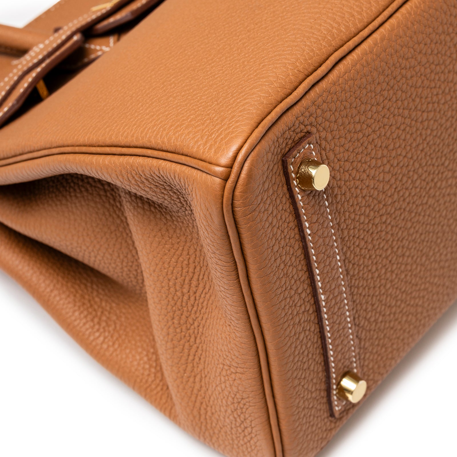 Close-up of Hermès Birkin 30 Gold Togo Gold Hardware showing corner stitching, textured leather, and metal feet details.