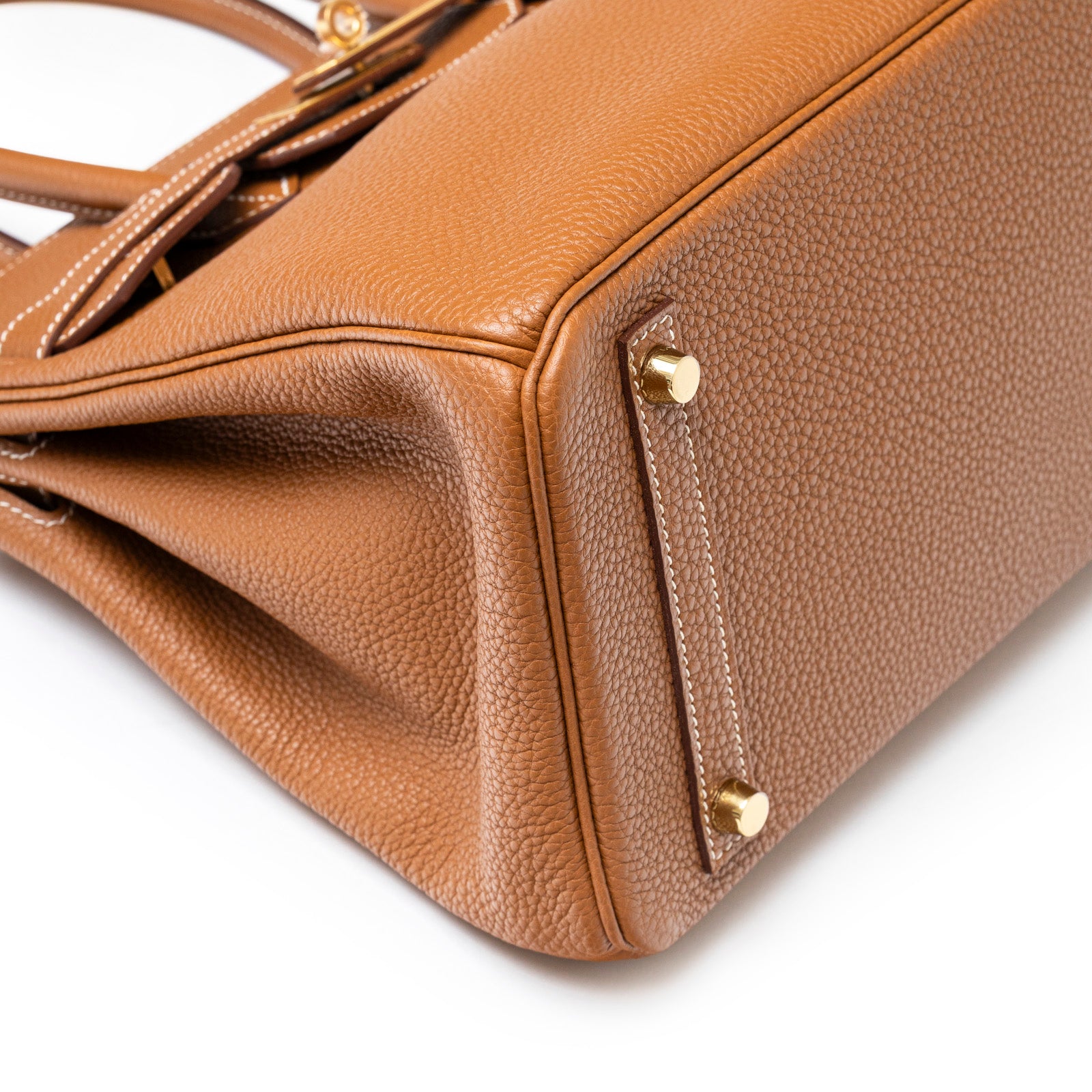 Close-up of the bottom corner showing Hermès Birkin 30 Gold Togo Gold Hardware leather texture and gold feet detail