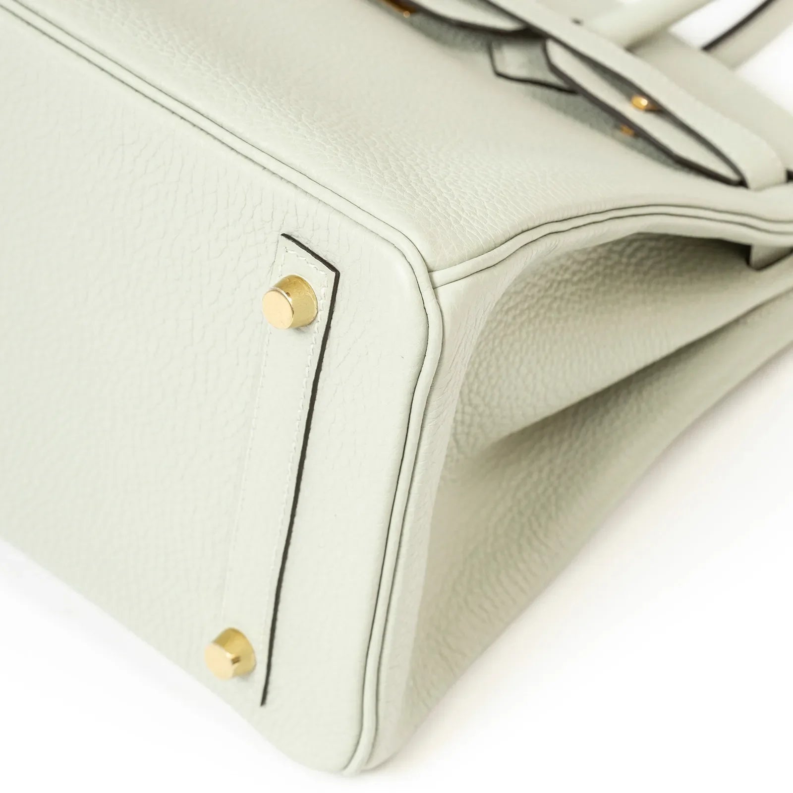 Close-up of bottom corner and gold hardware feet on Hermès Birkin 30 in Gris Neve Togo leather