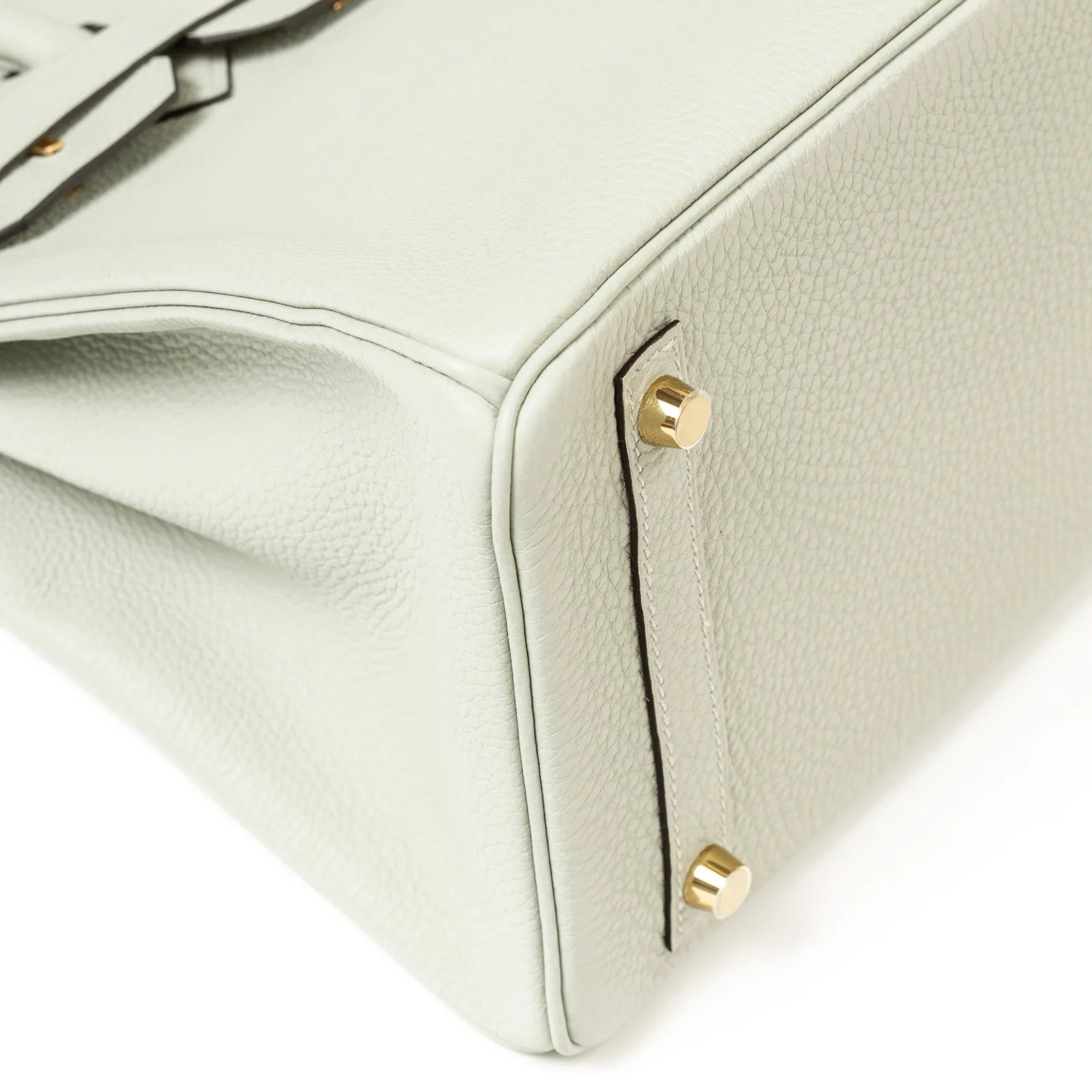 Close-up of the bottom corner of Hermès Birkin 30 in gris neve togo leather with gold hardware feet