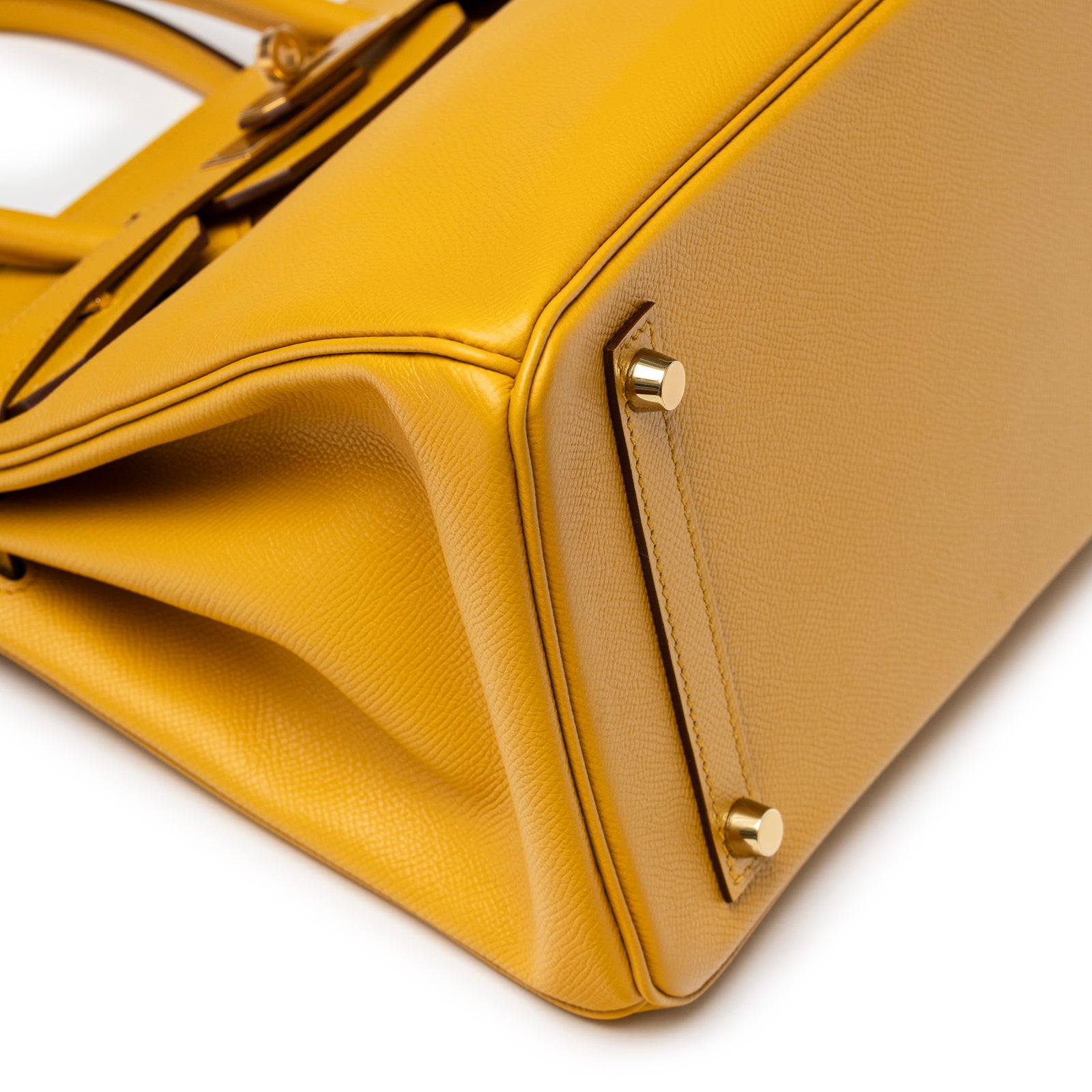 Close-up of base corner of Hermès Birkin 30 Jaune Ambre Epsom Gold Hardware showing leather texture and feet