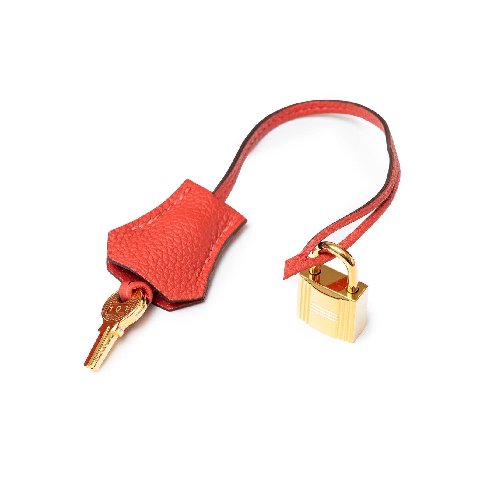 Close-up of Hermès Birkin 30 Rouge Pivoine Clemence Gold Hardware lock and key with leather strap detail